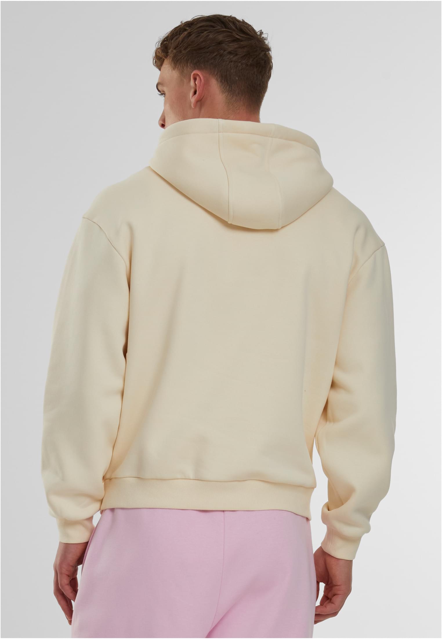 Baksidan av en man som bär en beige Fluffy Hoody.