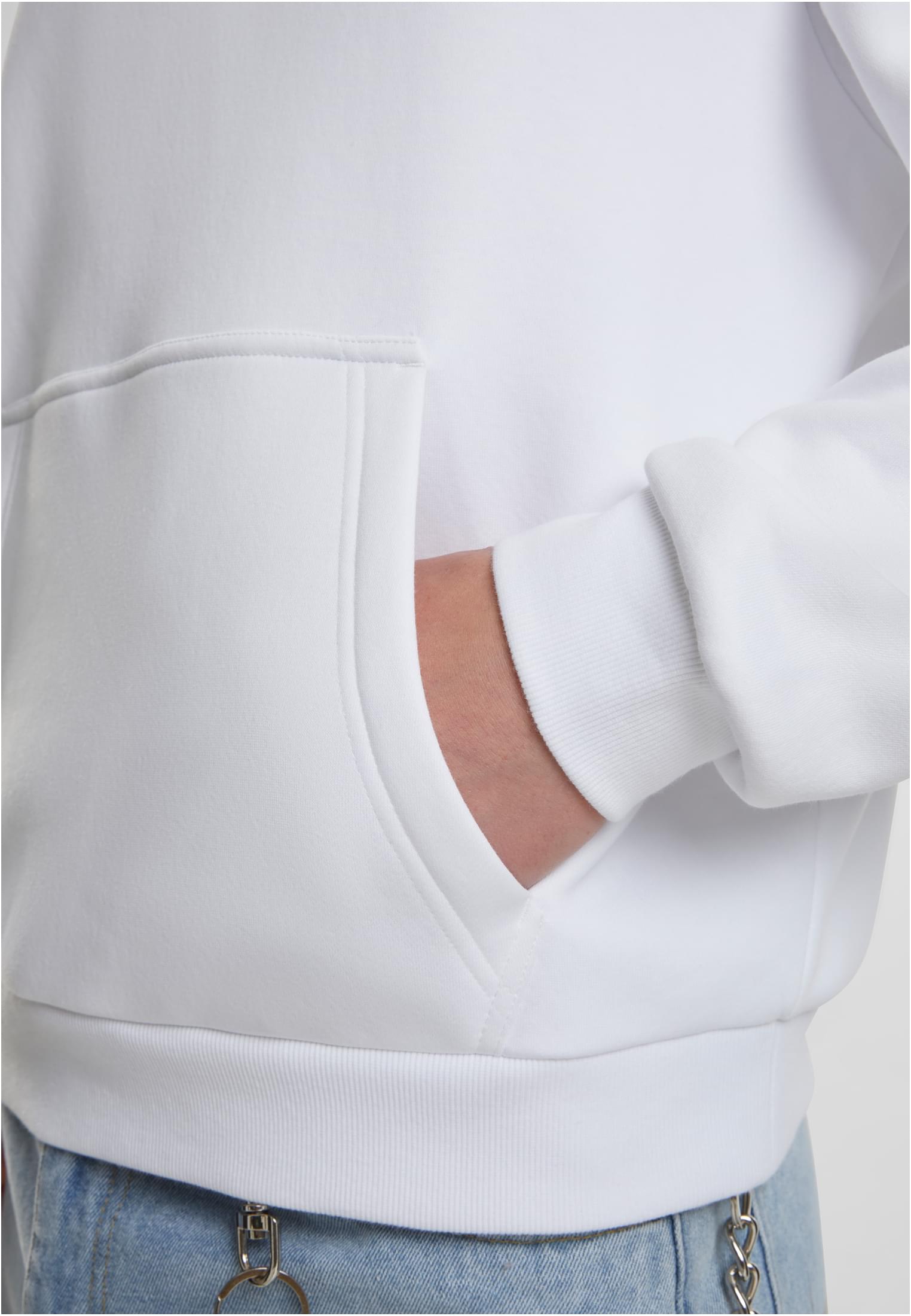 Närbild på en person som har handen i magfickan på en vit luvtröja.