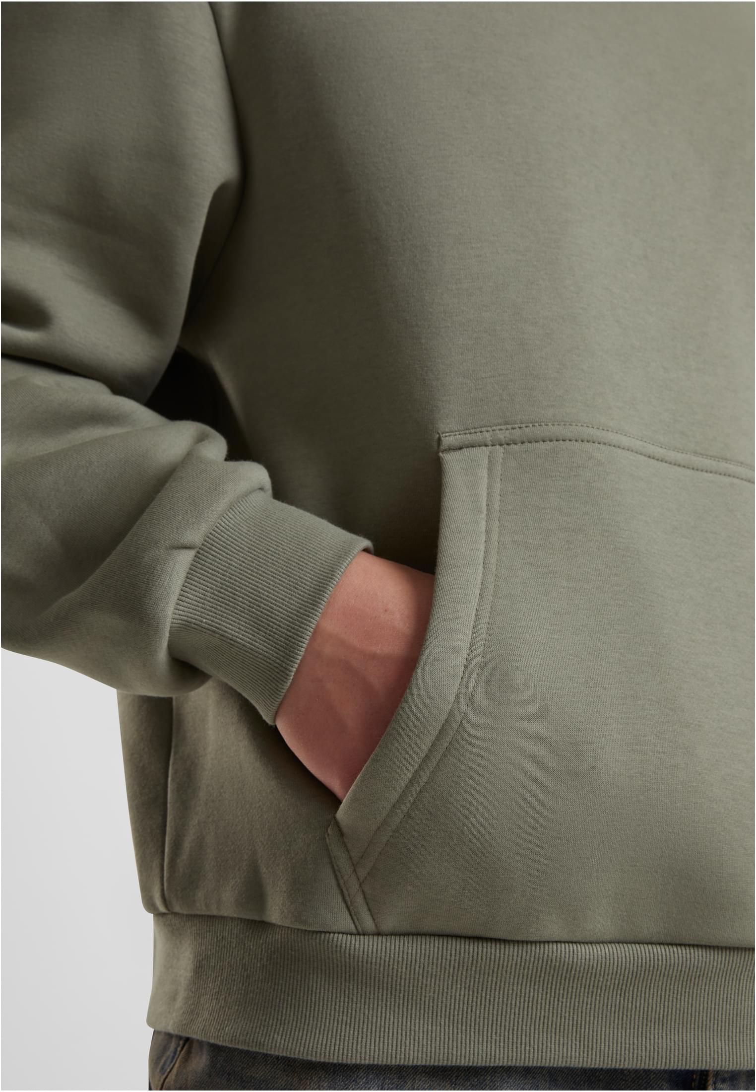 Närbild på en person med handen i kängurufickan på en Fluffy Hoody.