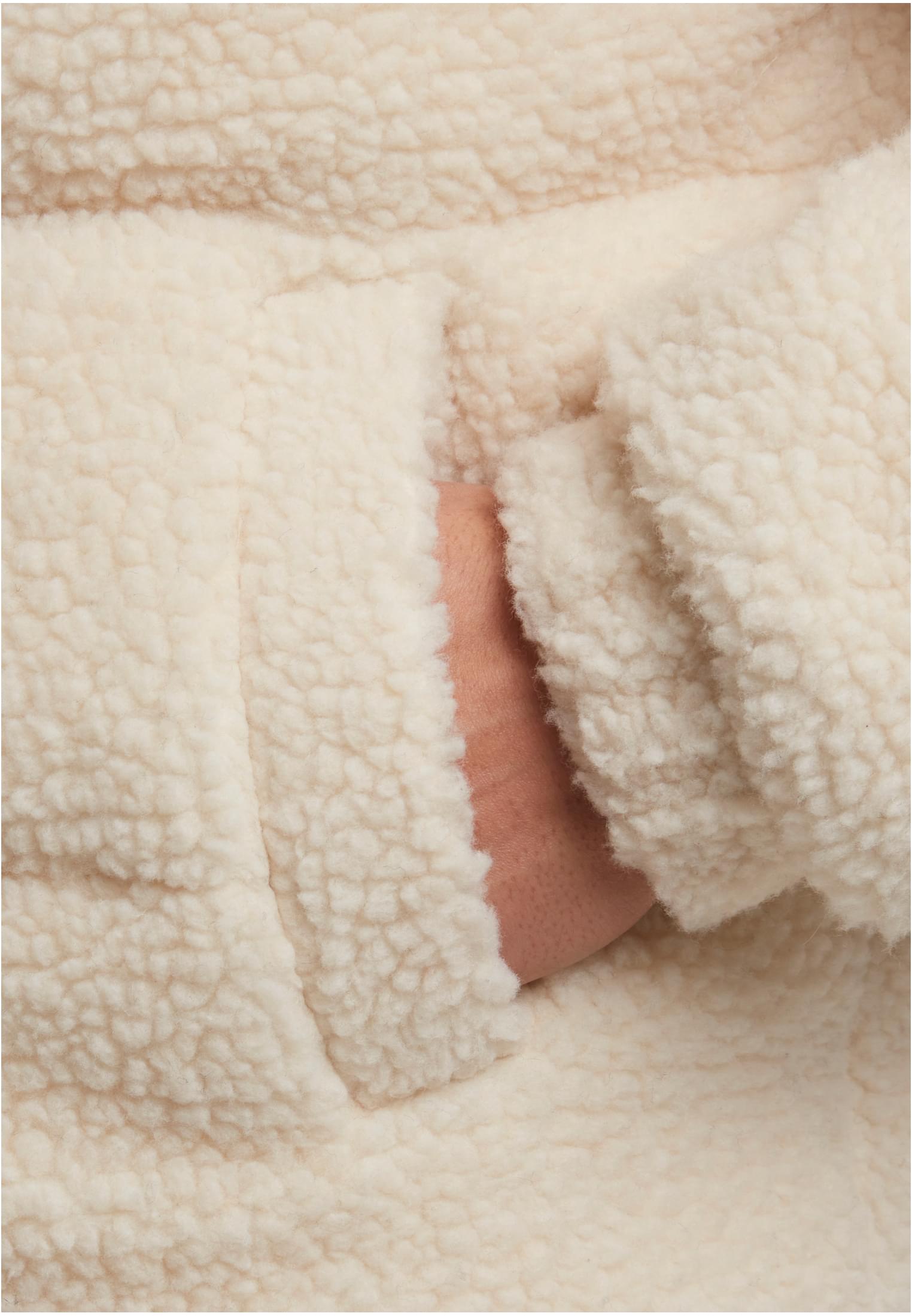 Närbild på fickan och det mjuka teddyfleecematerialet på en beige Fabric Mix Teddy Puffer Jacket.