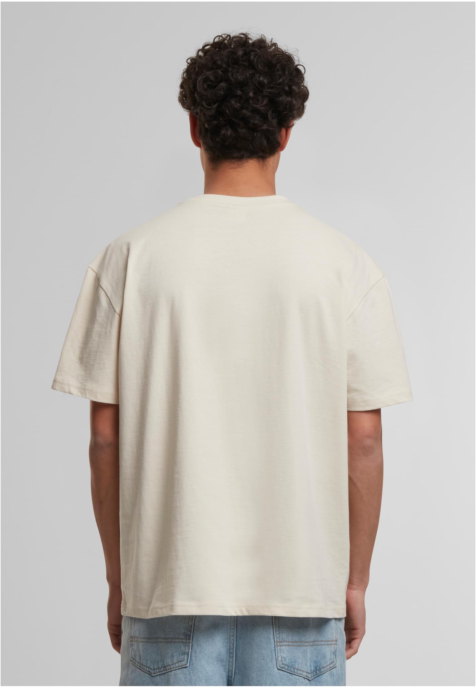 Baksidan av en man som bär en benvit Cotton Loose Tee från Urban Classics.