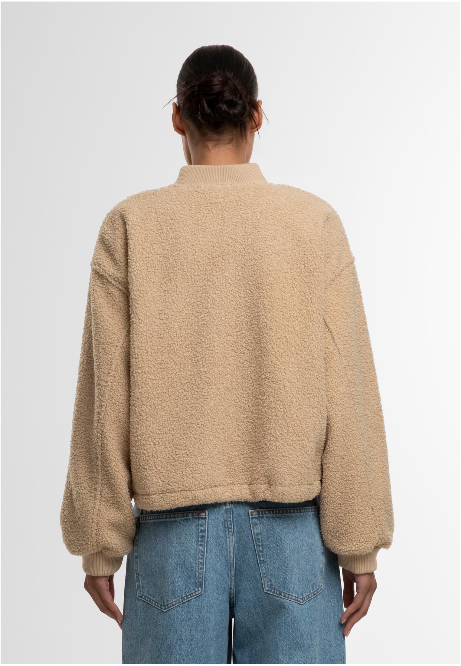 En kvinna visar baksidan av en beige UC Structured Bomber Jacket.