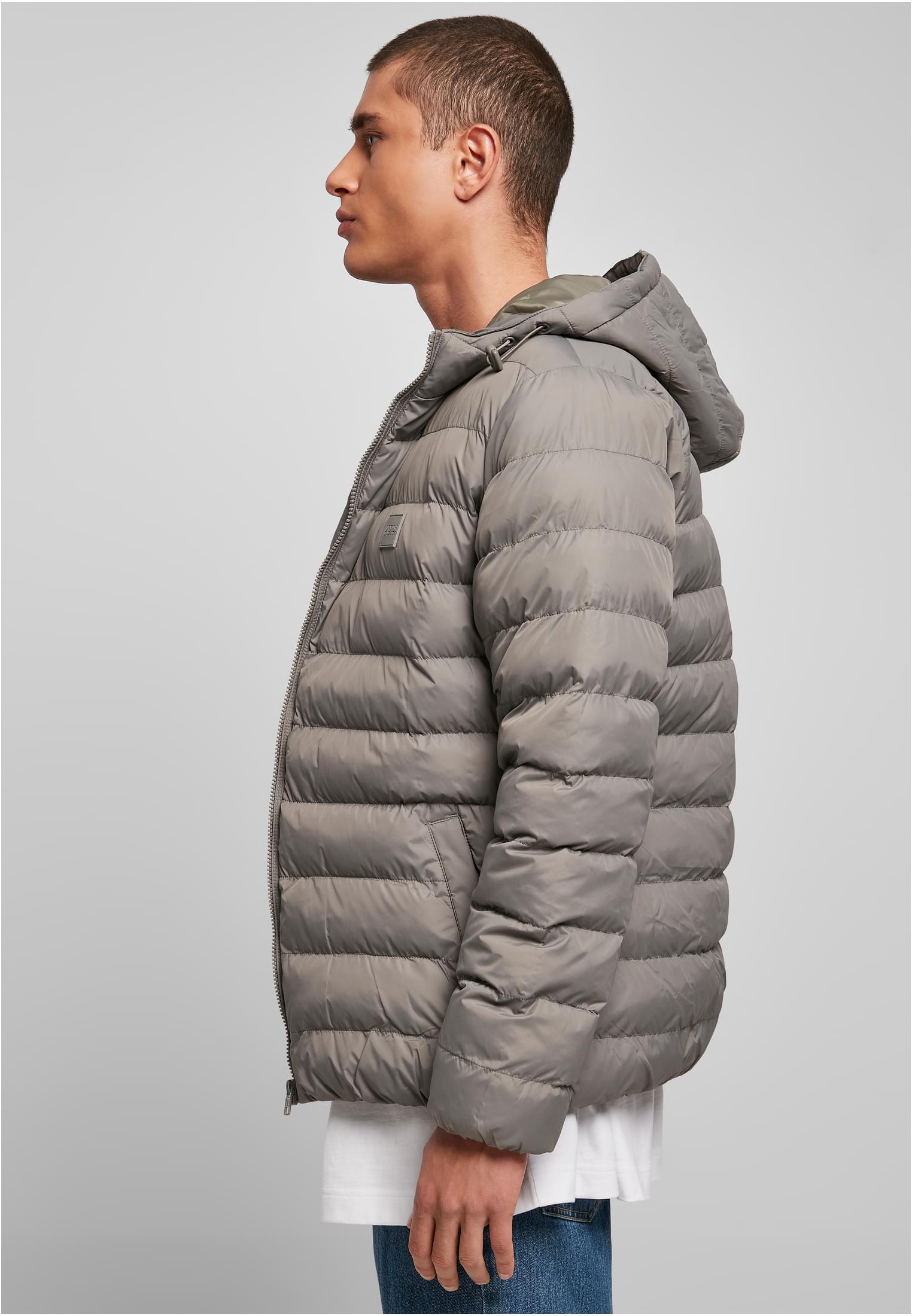 En man i profil som bär en grå, quiltad UC Basic Bubble Jacket.