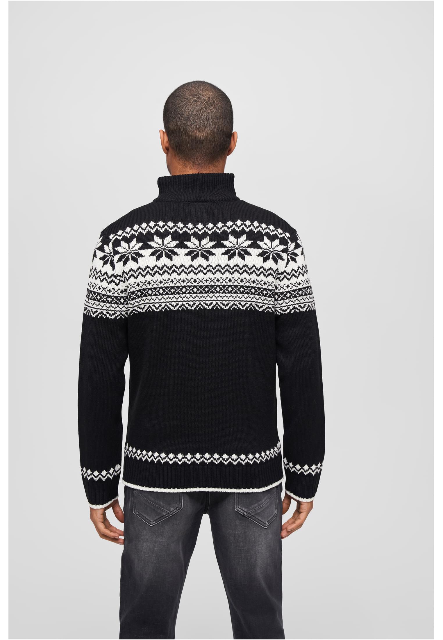 En man, sedd bakifrån, bär en svart stickad B Troyer Norweger-tröja med ett traditionellt vitt mönster över axlarna.