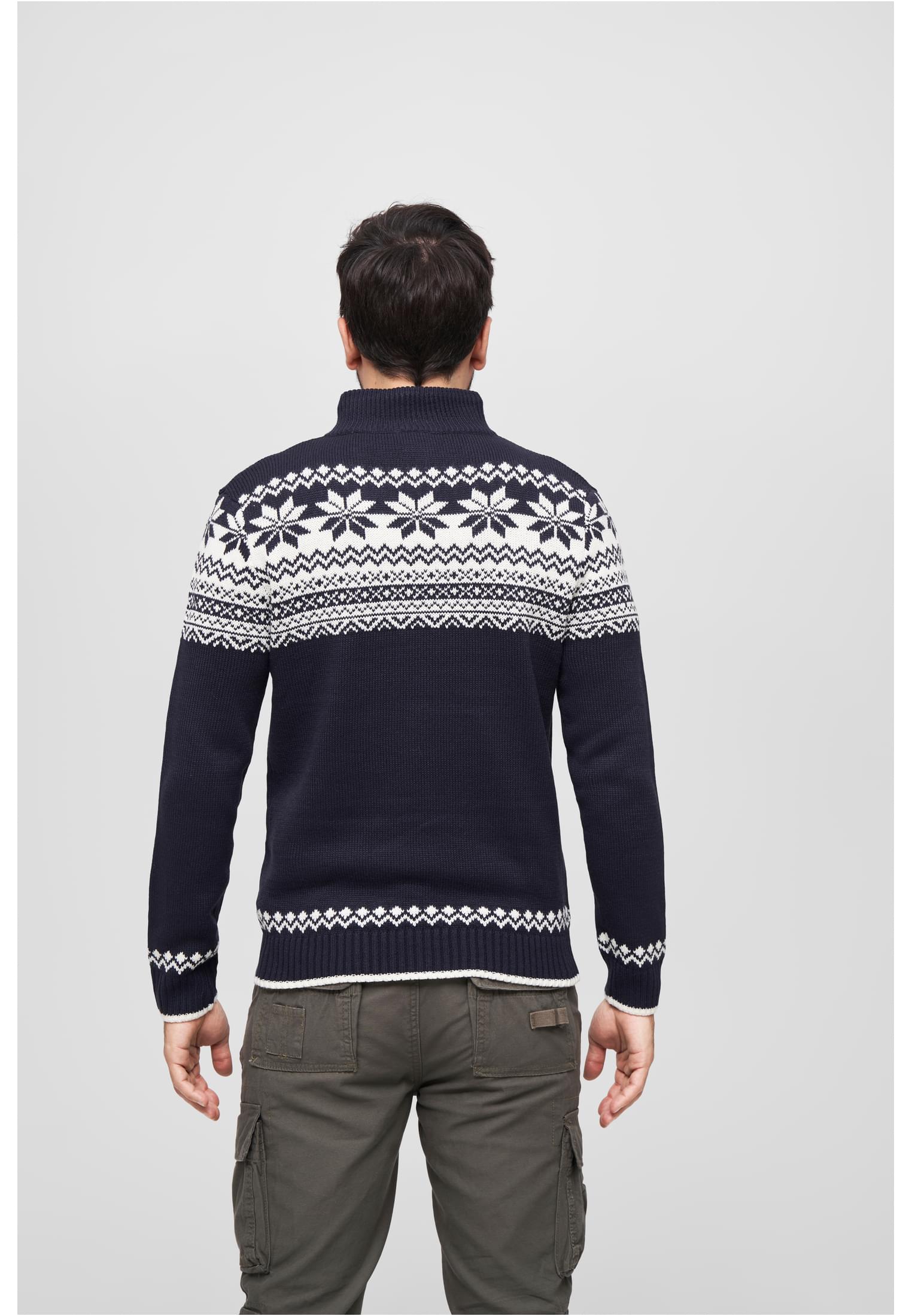 Baksidan av en man som bär en mörkblå stickad tröja med ett traditionellt vitt, norskt mönster.