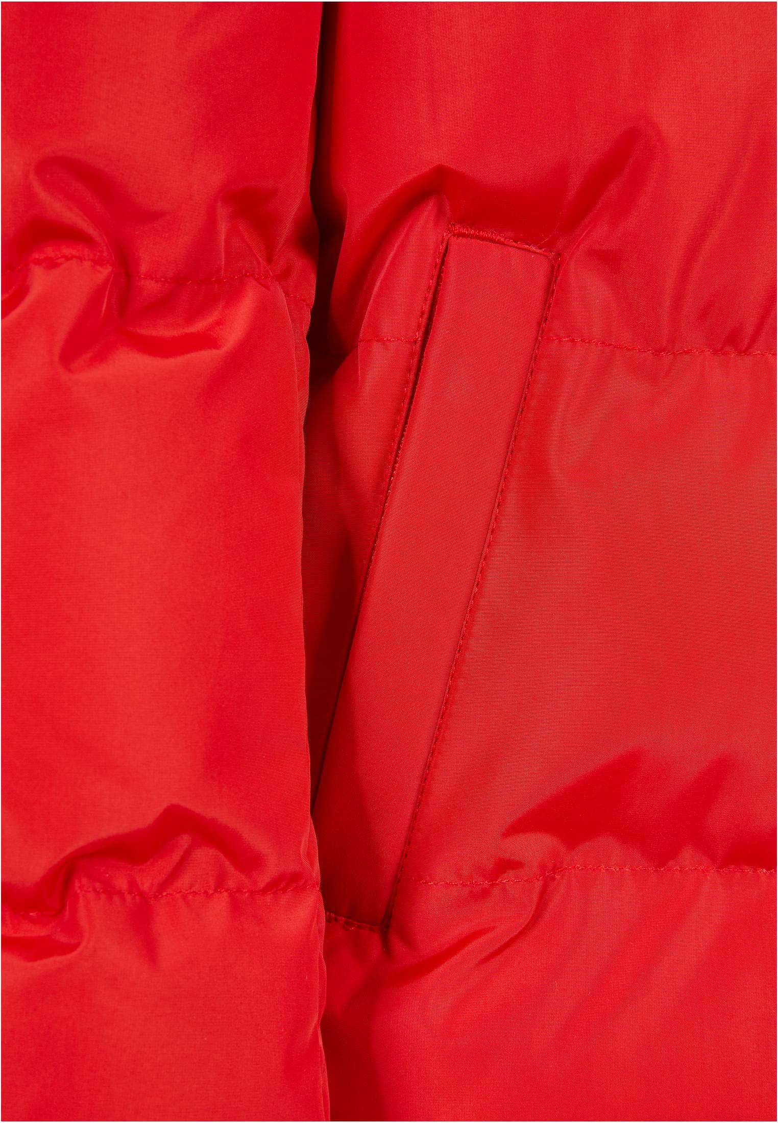 Närbild på den röda UC Boys Hooded Puffer Jacket som visar detaljer av sidofickan och det glansiga materialet.