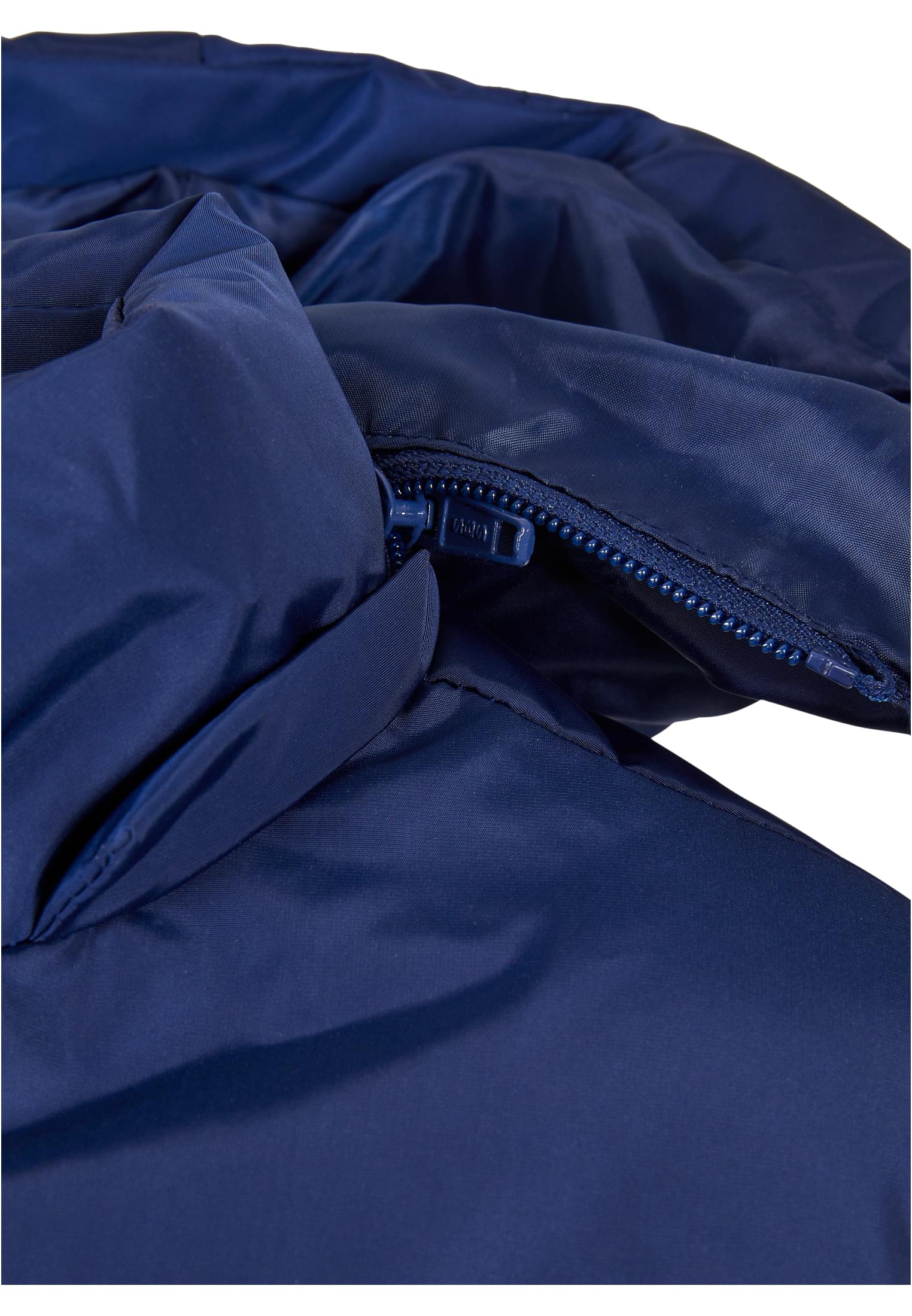 Närbild på dragkedjan och den quiltade kragen på en marinblå UC Boys Hooded Puffer Jacket.