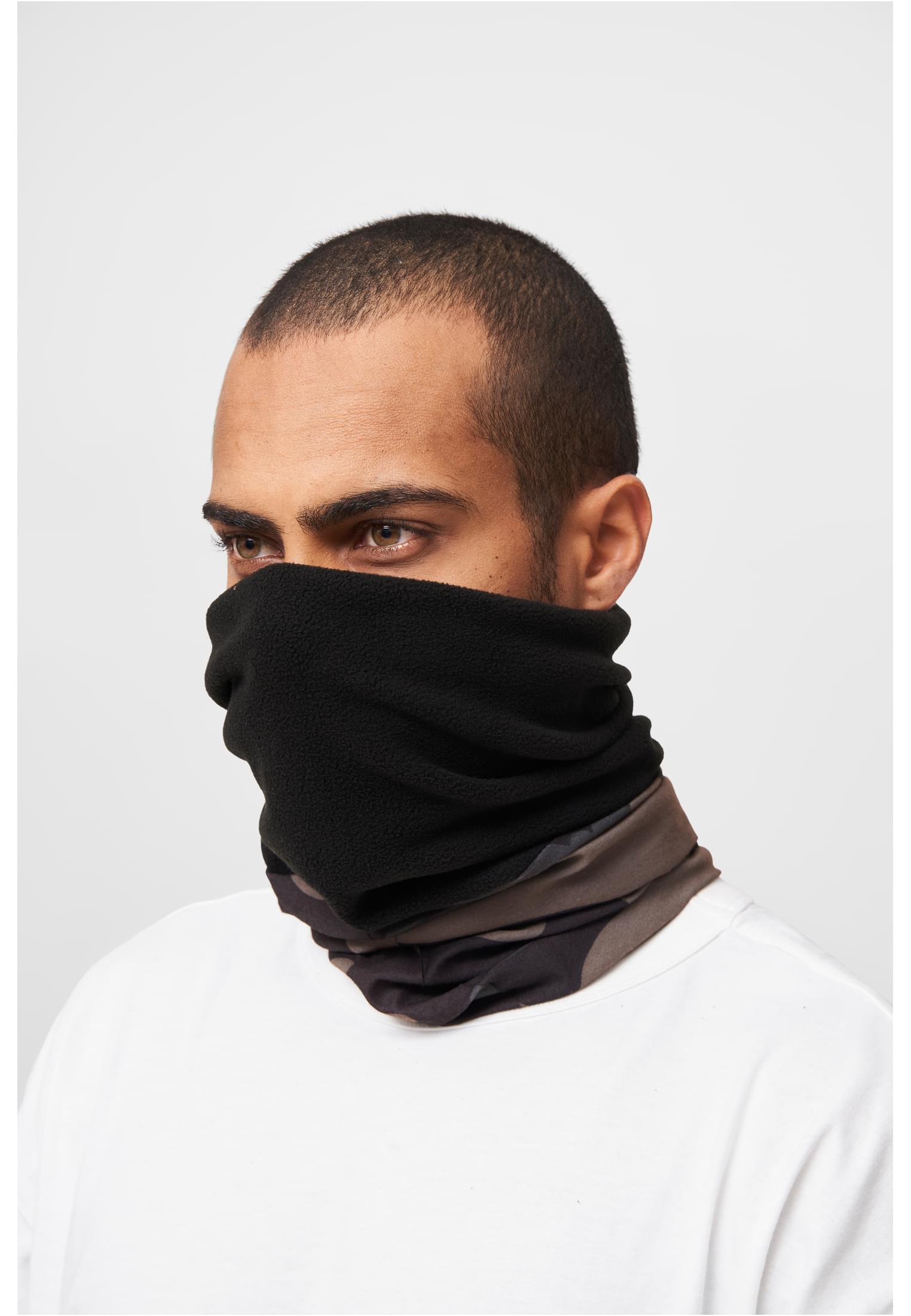 En man bär en svart och kamouflagemönstrad loophalsduk i fleece, uppdragen över näsa och mun.