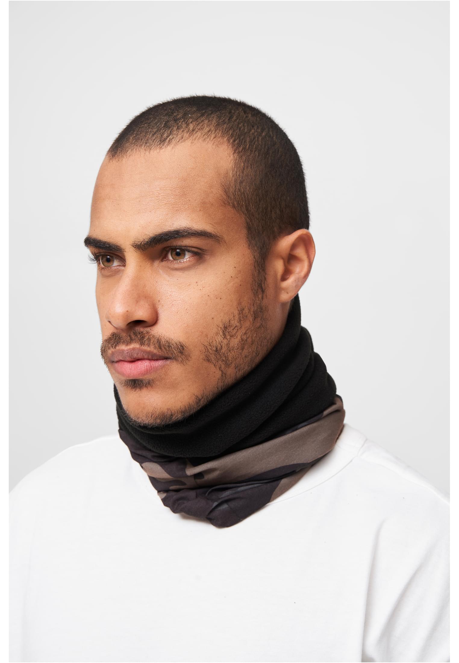 Närbild på en man som bär en loophalsduk med svart fleece och kamouflagemönster.