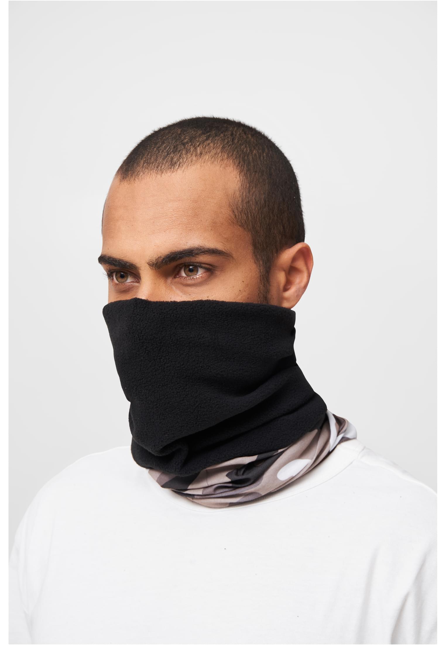 En man bär en svart och kamouflagemönstrad fleecehalsduk uppdragen över ansiktet.