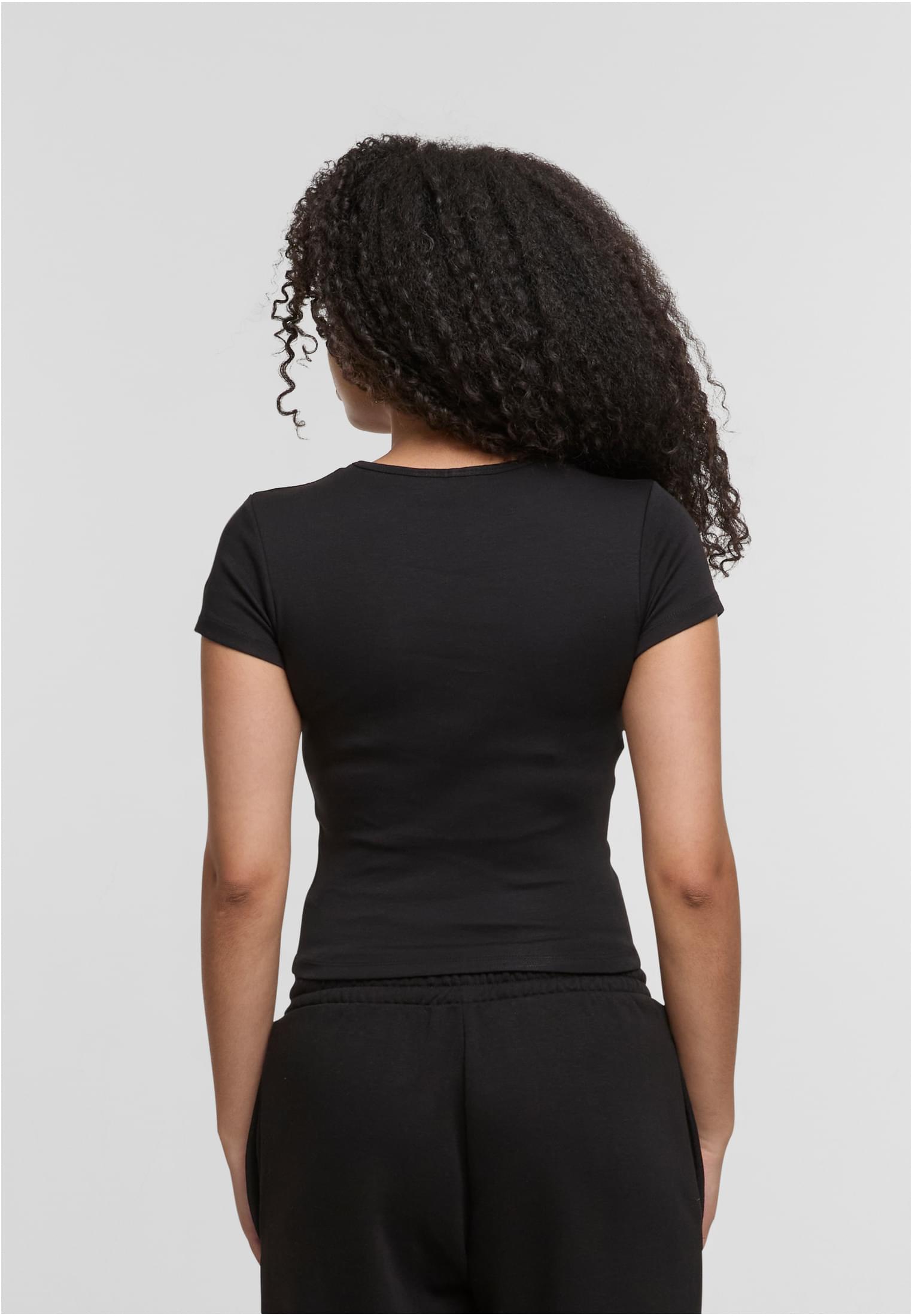 En kvinna visar baksidan av den svarta DEF Relax T-shirten.