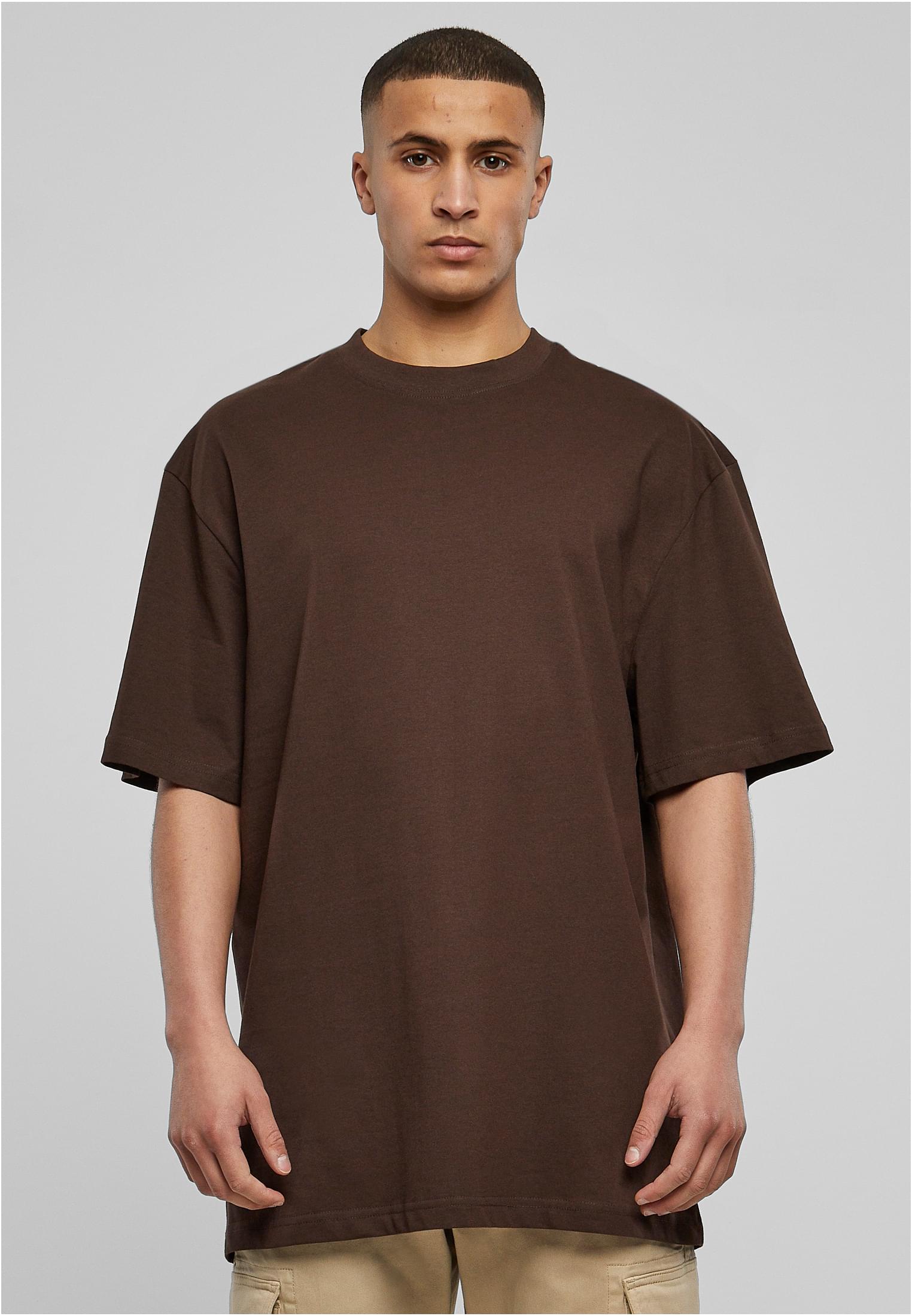 En manlig modell i en brun oversized t-shirt, sedd framifrån.
