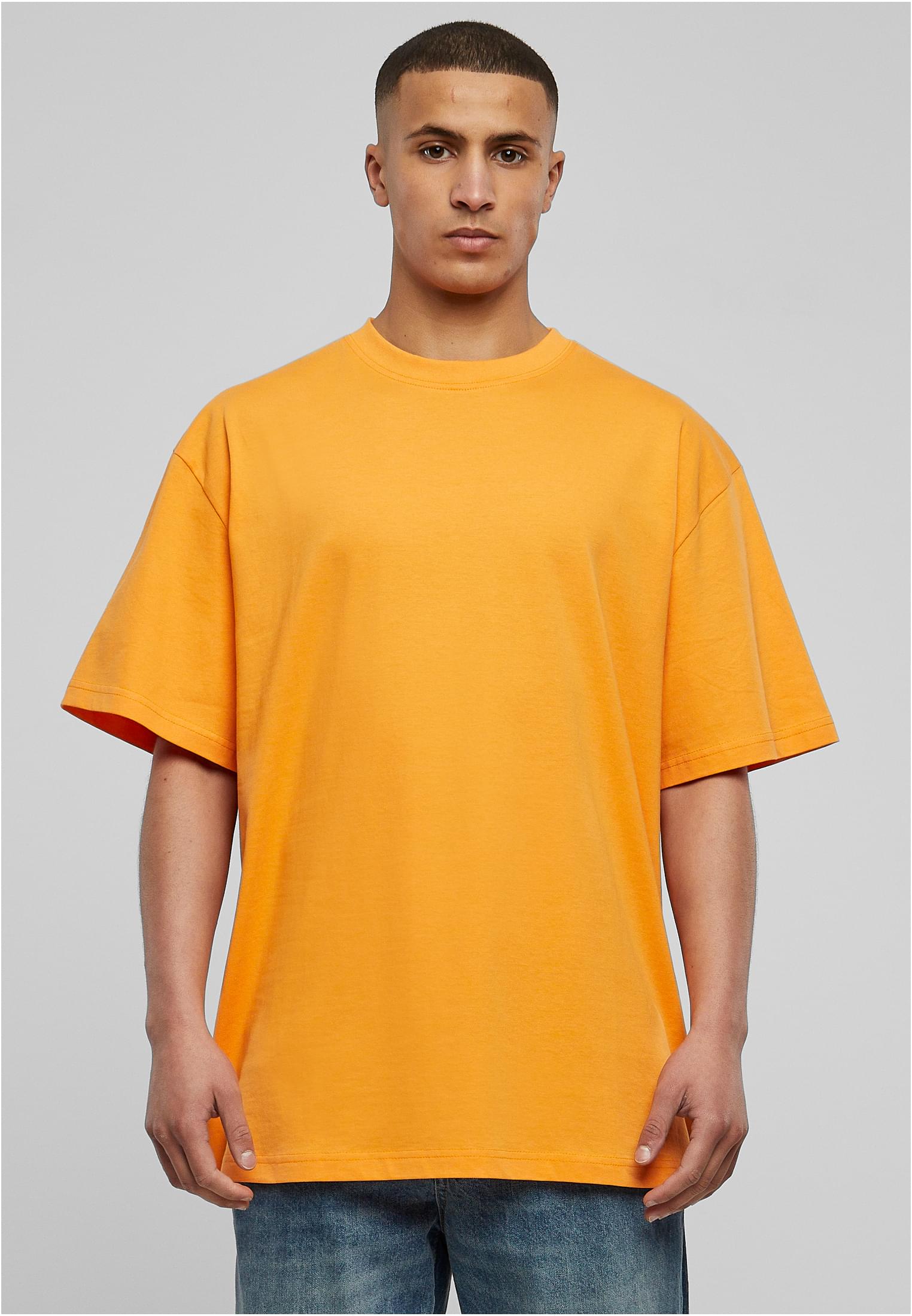 Manlig modell i en orange Tall Tee från Urban Classics.