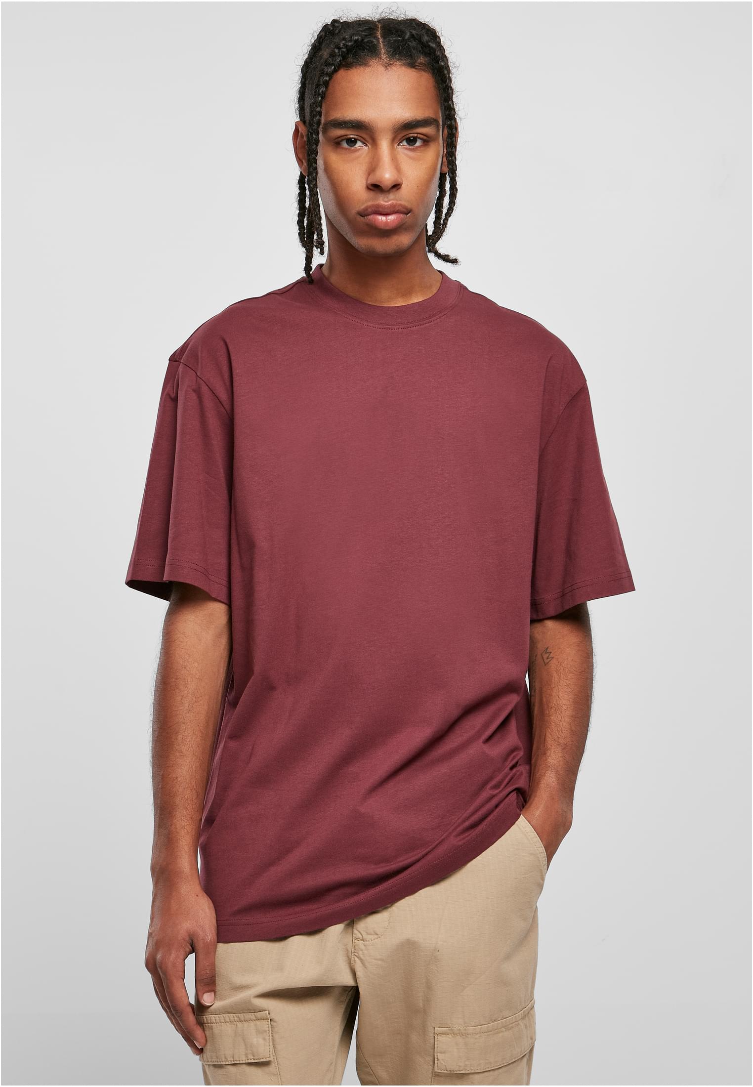 Manlig modell bär en vinröd Tall Tee från Urban Classics.