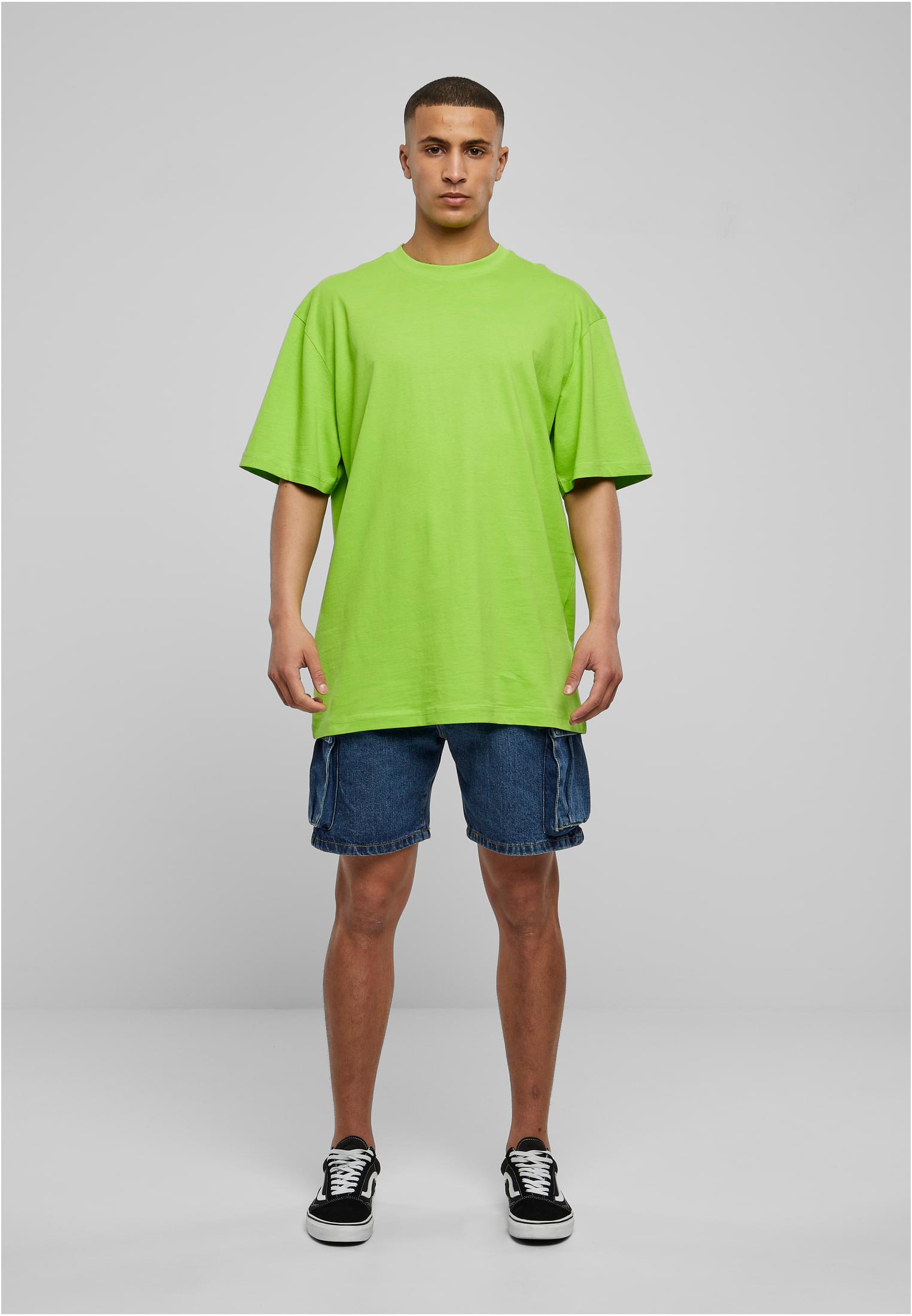 Manlig modell som visar upp en frostmint-färgad Tall Tee från Urban Classics, stylad med jeansshorts och sneakers.