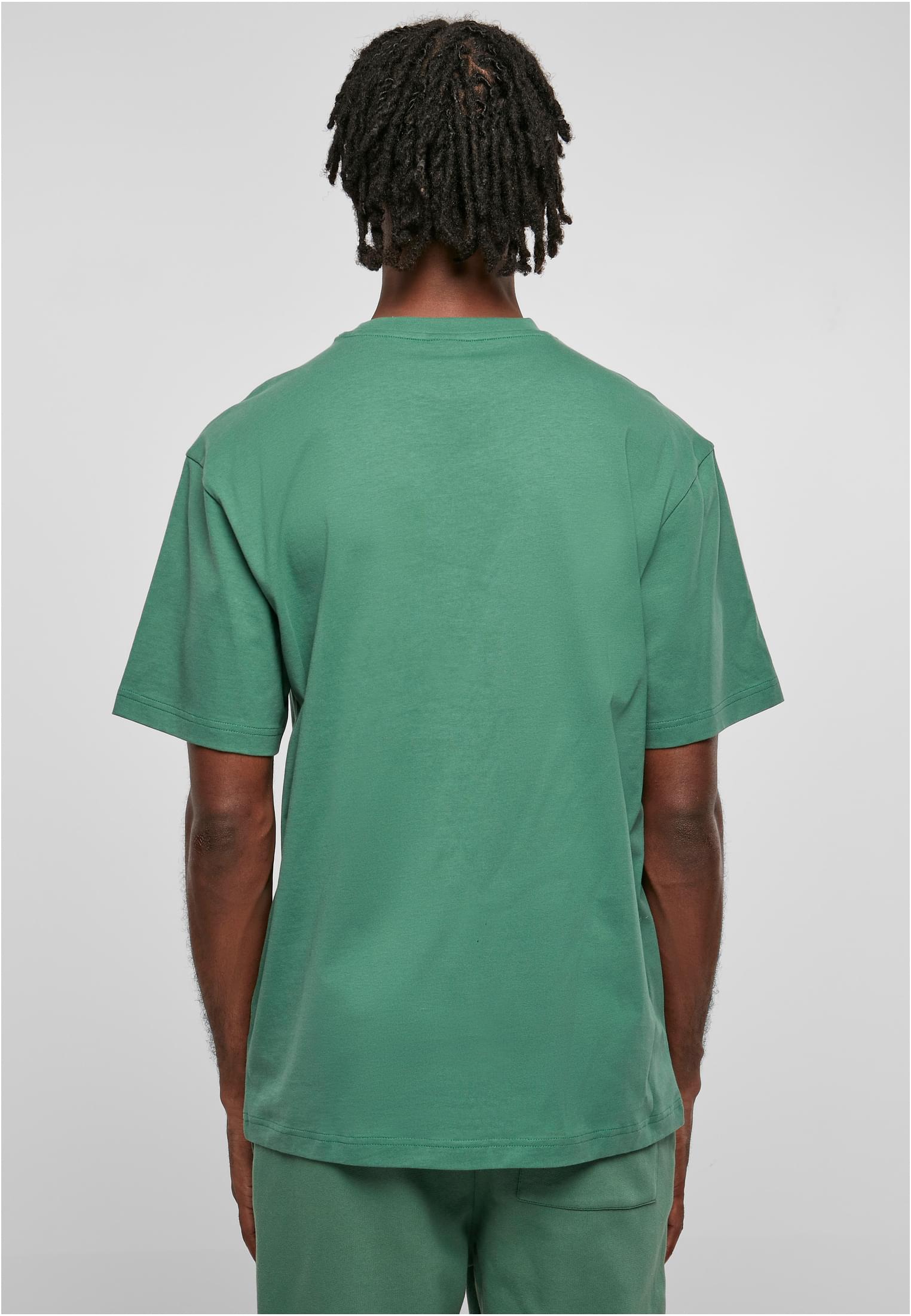 Baksidan av en manlig modell som bär en mintgrön Tall Tee.