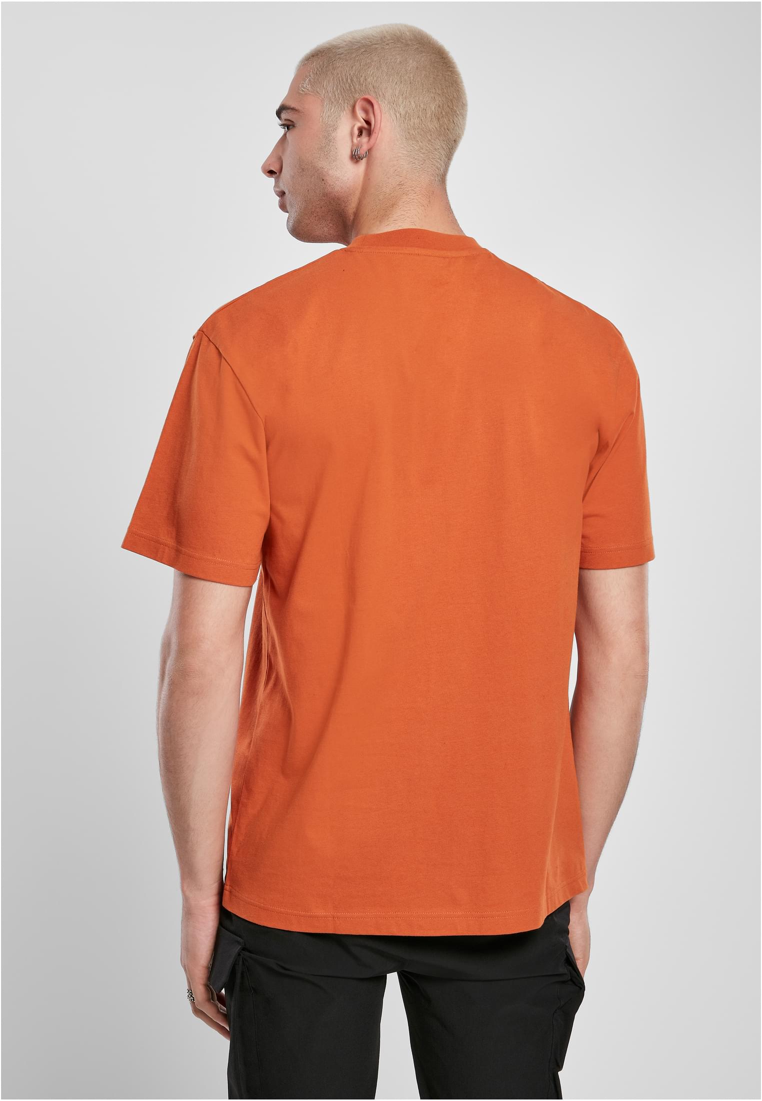 Man fotograferad snett bakifrån, iklädd en orange Tall Tee.