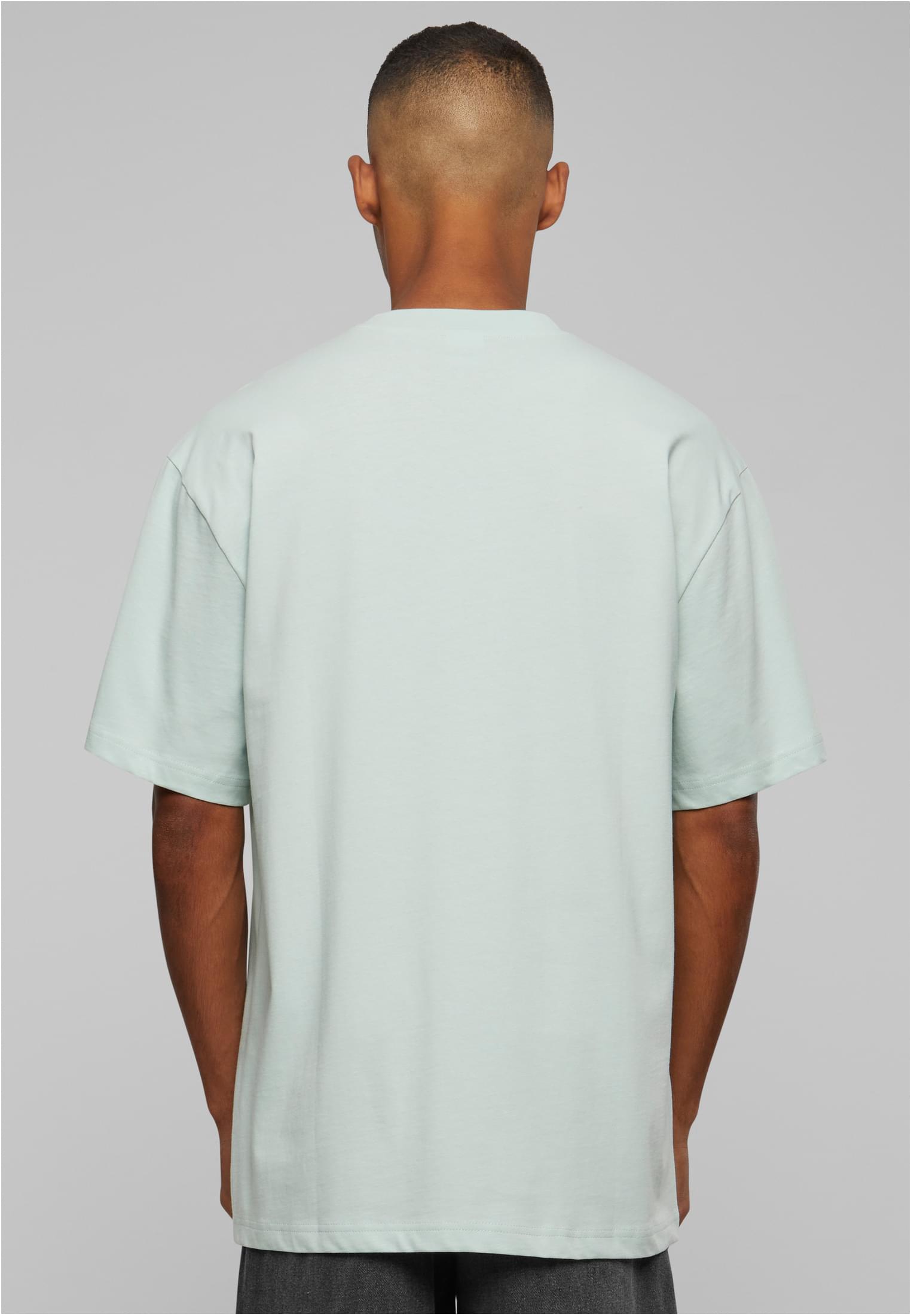 En man fotograferad bakifrån som bär en mintgrön Tall Tee från Urban Classics.