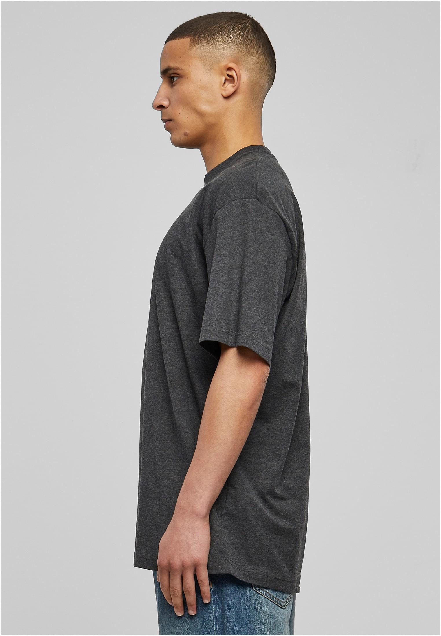 Sidoprofil av en man som bär en mörkgrå t-shirt och jeans mot en ljusgrå bakgrund.