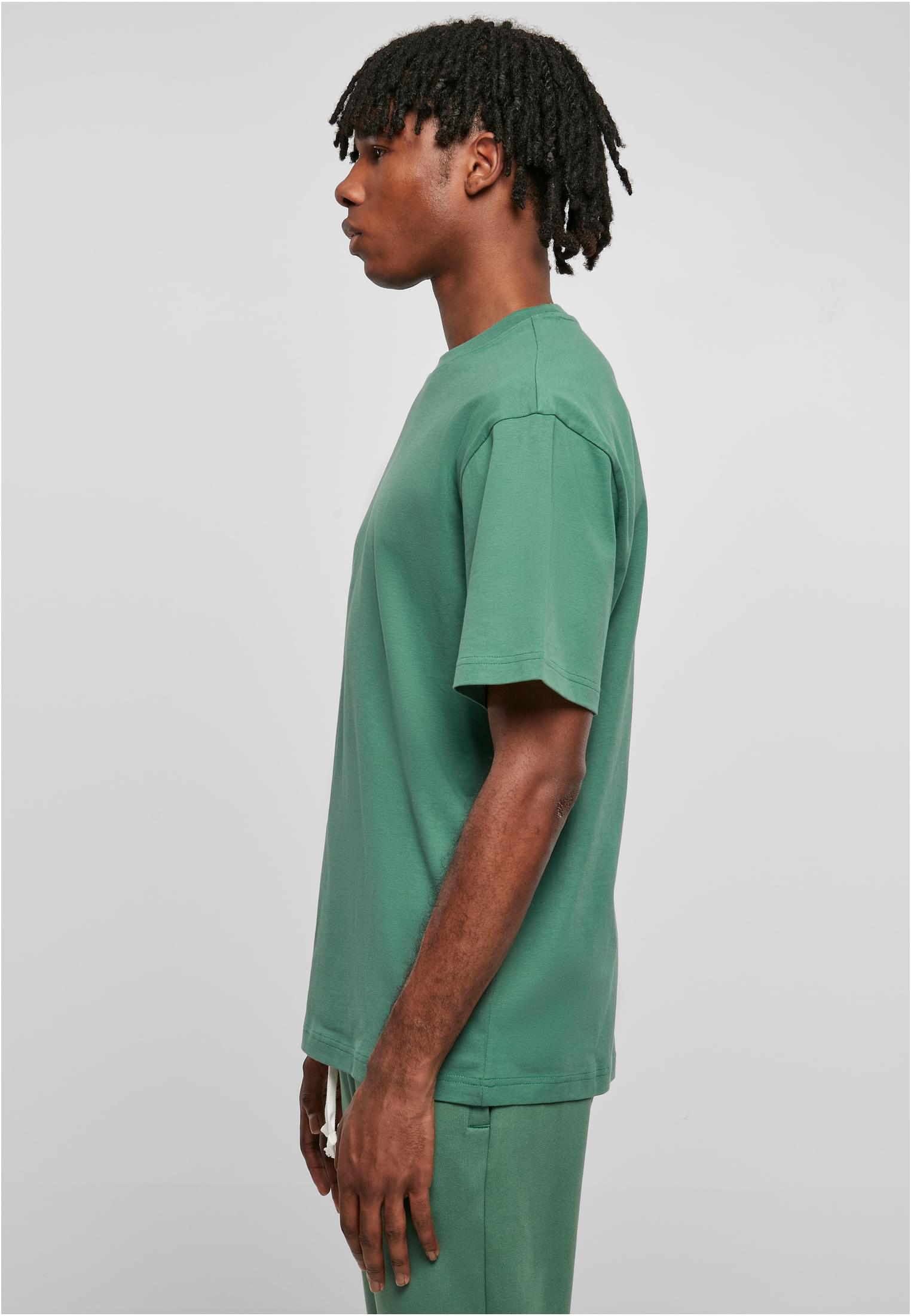 Sidovy av en man som bär en mintgrön Tall Tee.