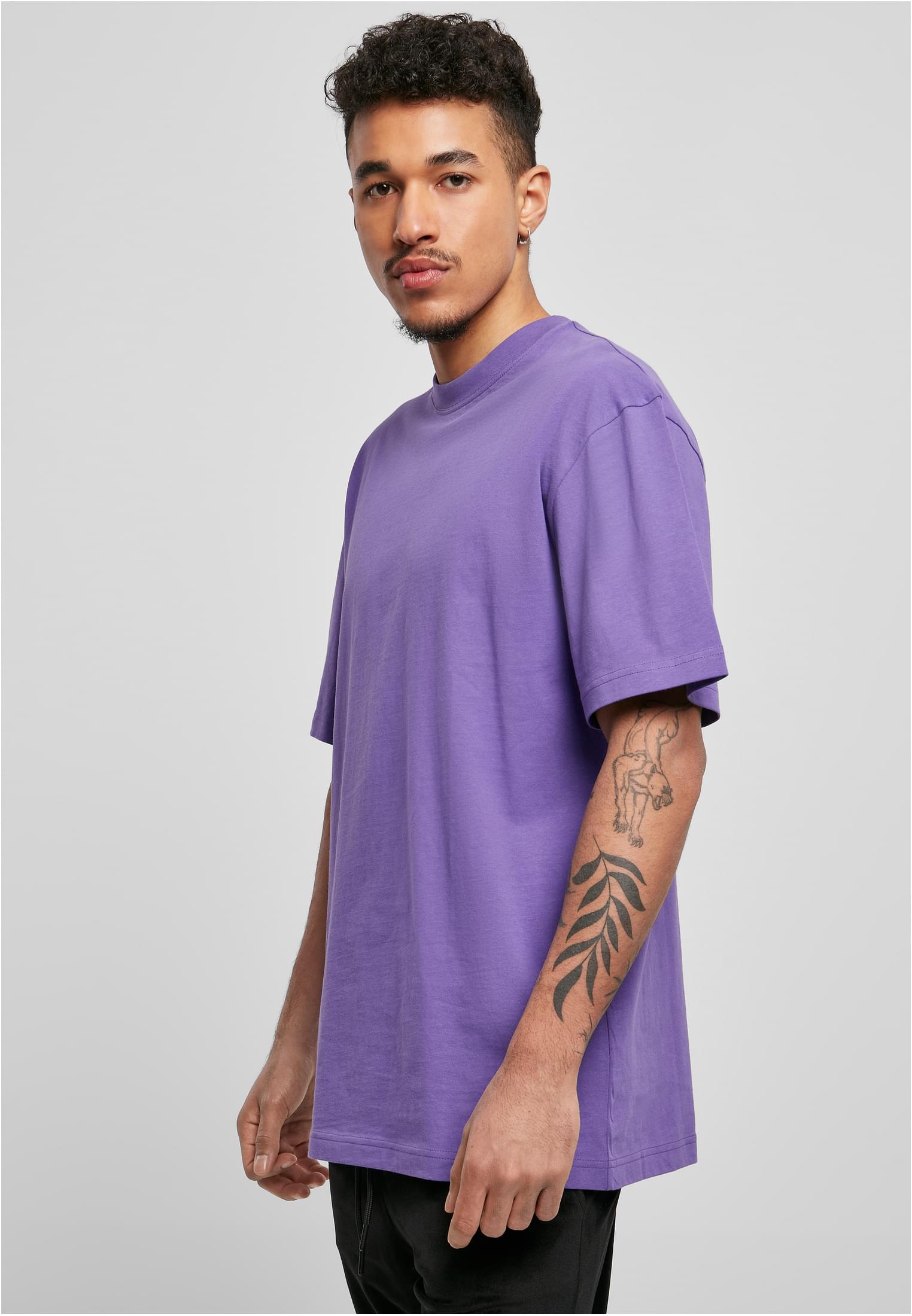 Sido-vy av en manlig modell som bär en lila Tall Tee från Urban Classics.