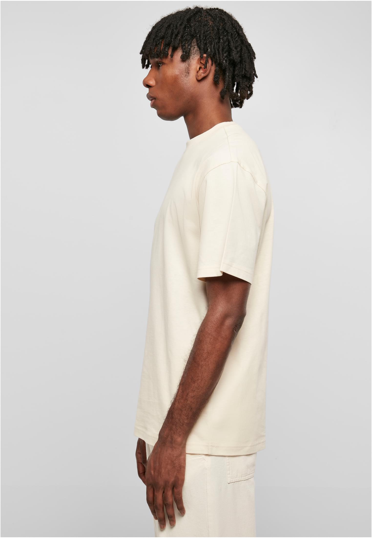 Sidoprofil av en man som bär en ljus Tall Tee med extra lång passform.