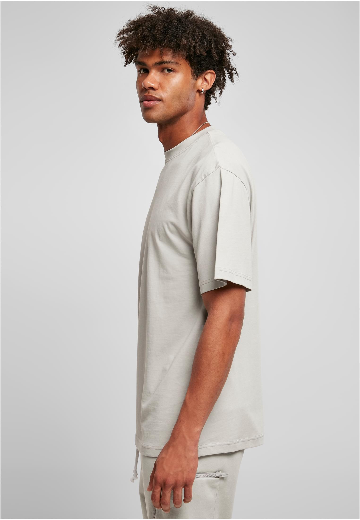 En man i profil som bär en mintgrön Tall Tee.