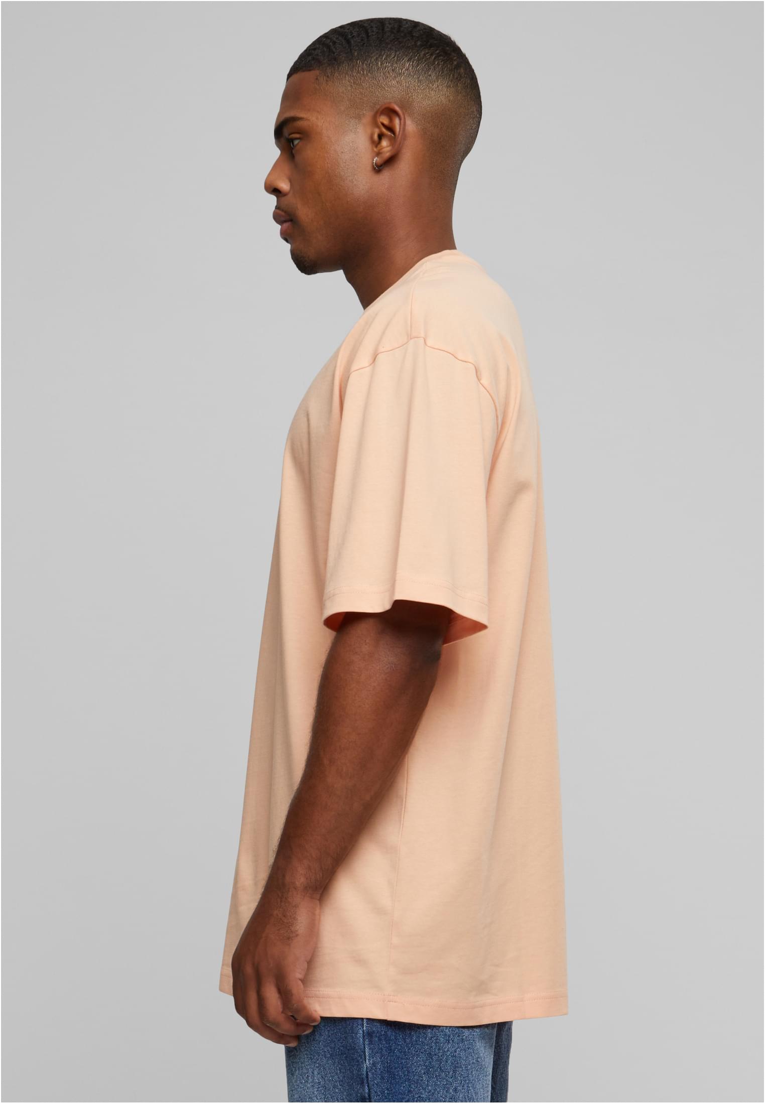 Man i profil som bär en frostmint-färgad Tall Tee med extra lång passform.