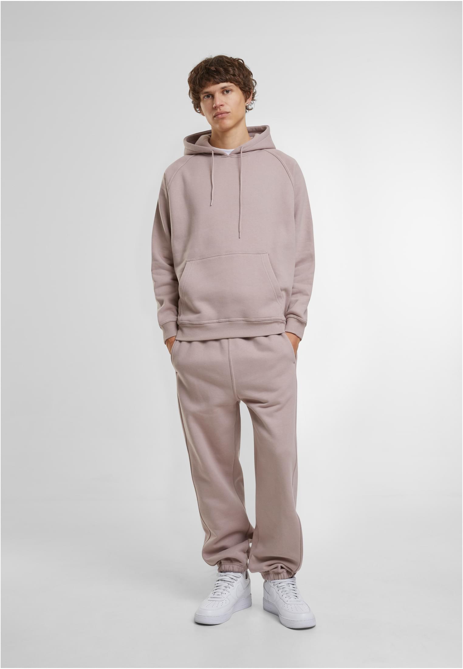 Manlig modell i ljusbruna UC Sweatpants och matchande hoodie.