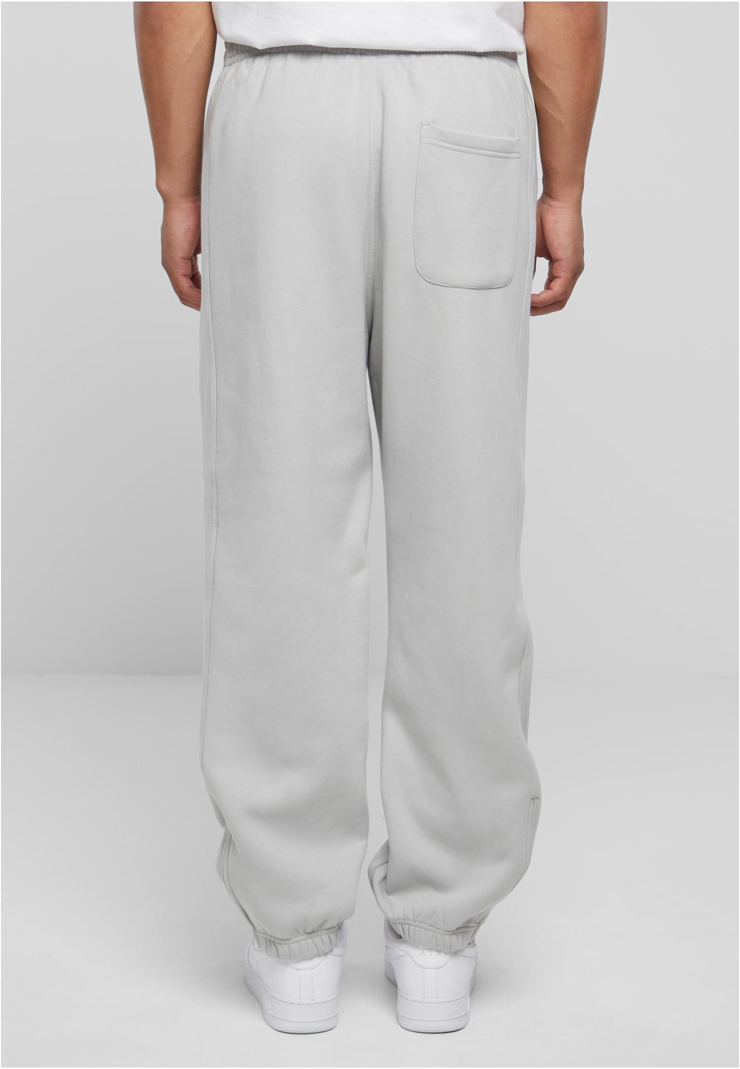 Baksidan av en modell som bär ljusgrå UC Sweatpants med en bakficka och resårmuddar vid anklarna.