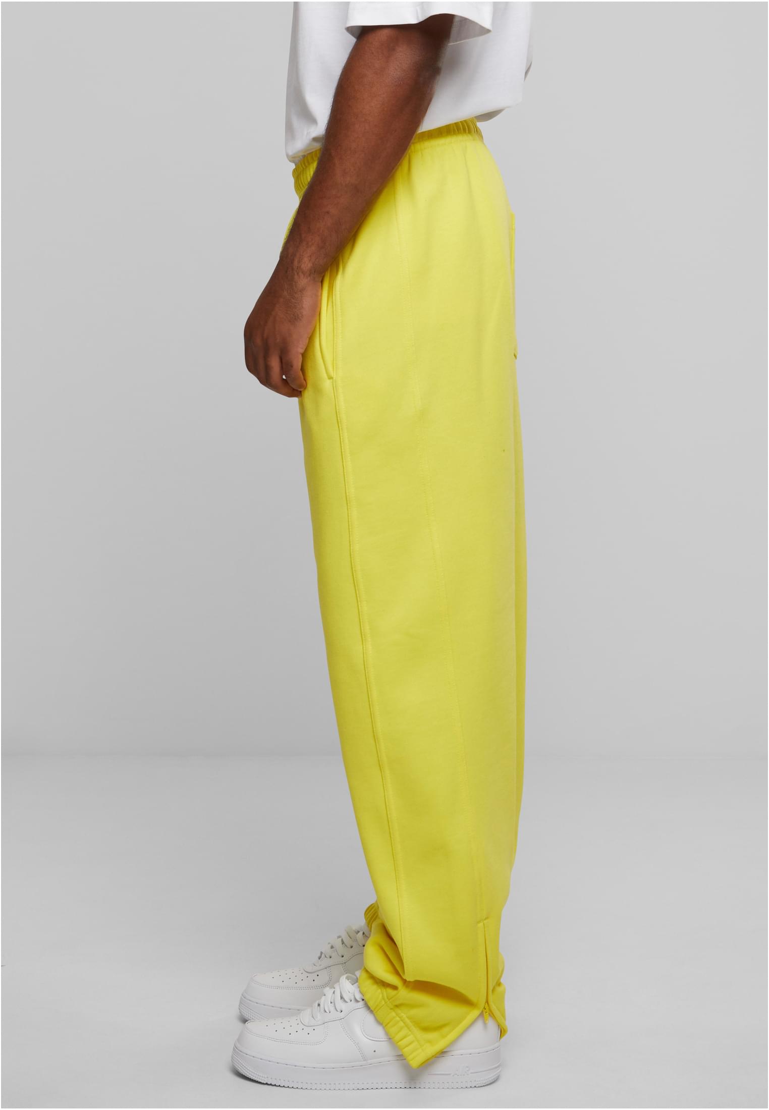 Sidovy av en man som bär gula UC Sweatpants.