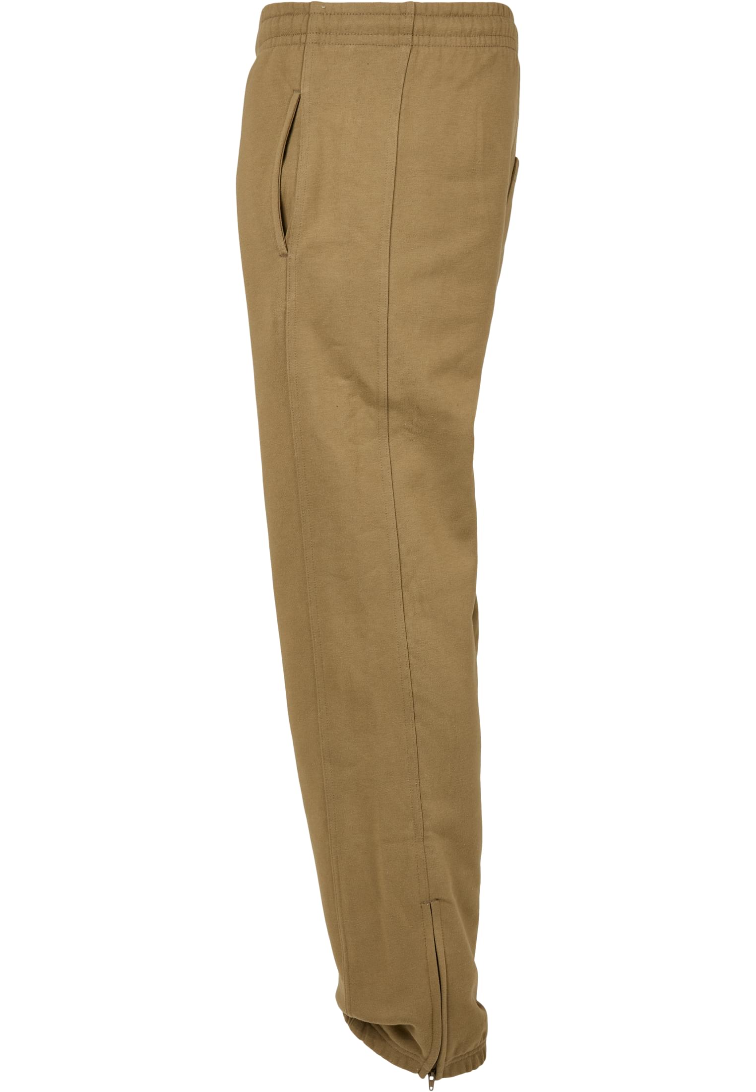 Ett par beiga UC Sweatpants fotograferade från sidan mot en vit bakgrund, som visar detaljer som sidofickan och dragkedjan vid ankeln.
