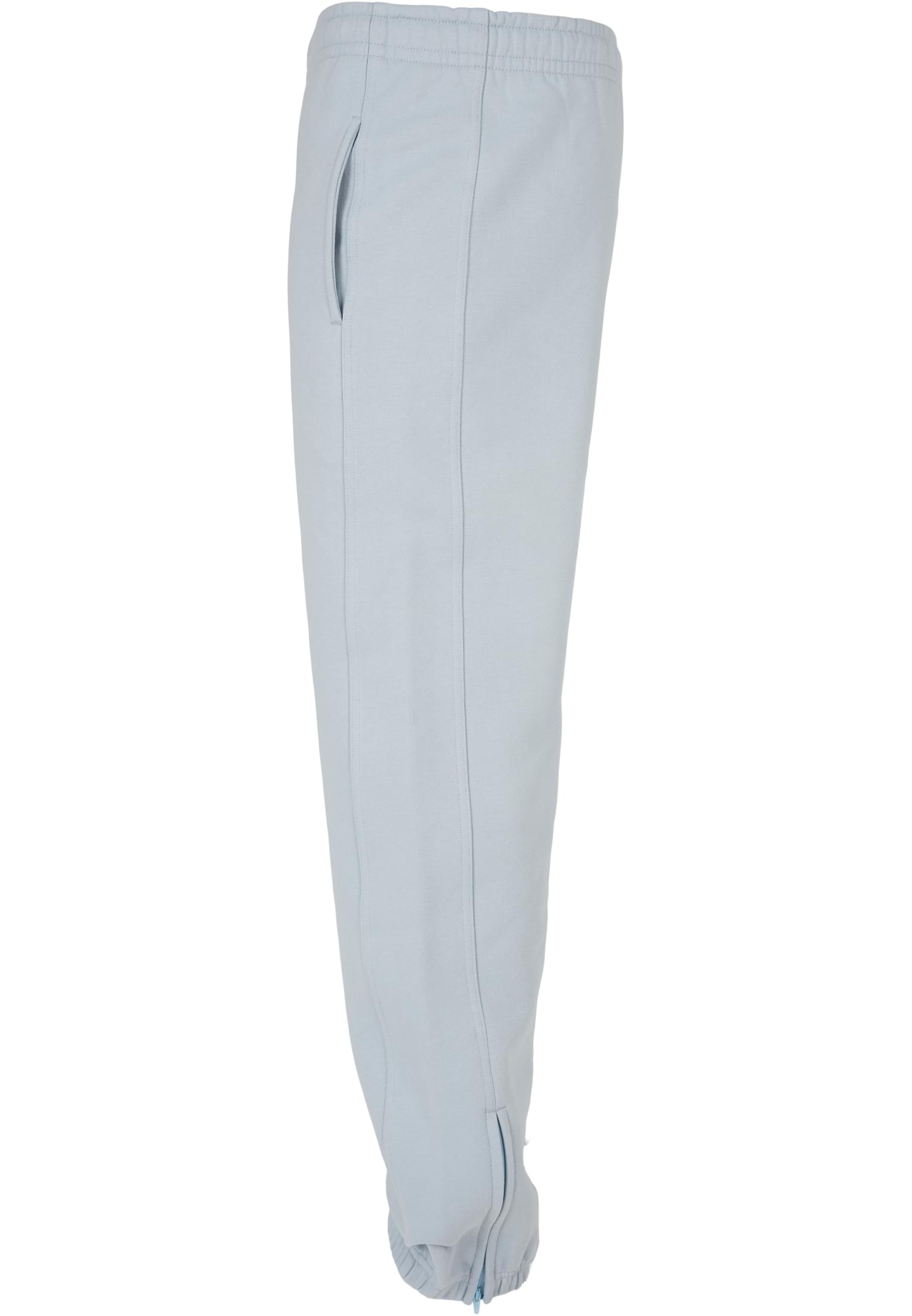 Sidovy av ett par ljusblå UC Sweatpants för herr mot en vit bakgrund, som visar detaljer som sidoficka och en dragkedja vid benslutet.