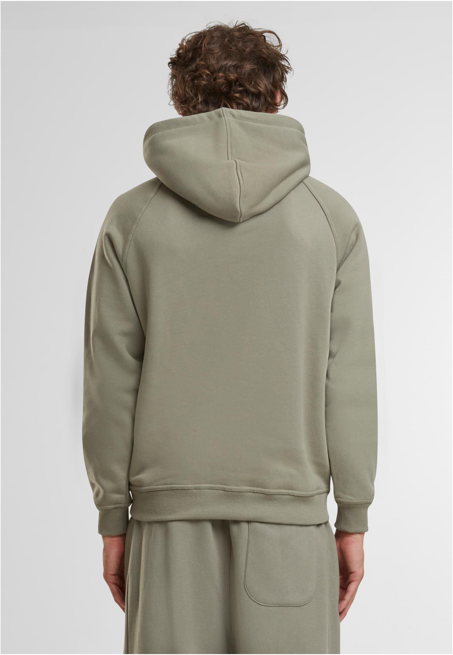 Manlig modell som visar baksidan av den blekgröna UC Blank Hoody.