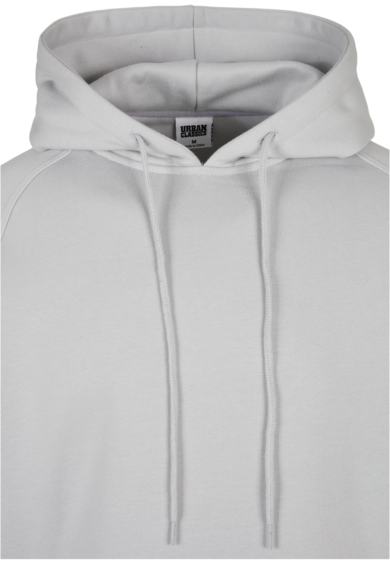 Närbild på kragen och huvan på den ljusgröna huvtröjan UC Blank Hoody, där märkesetiketten från Urban Classics är synlig.
