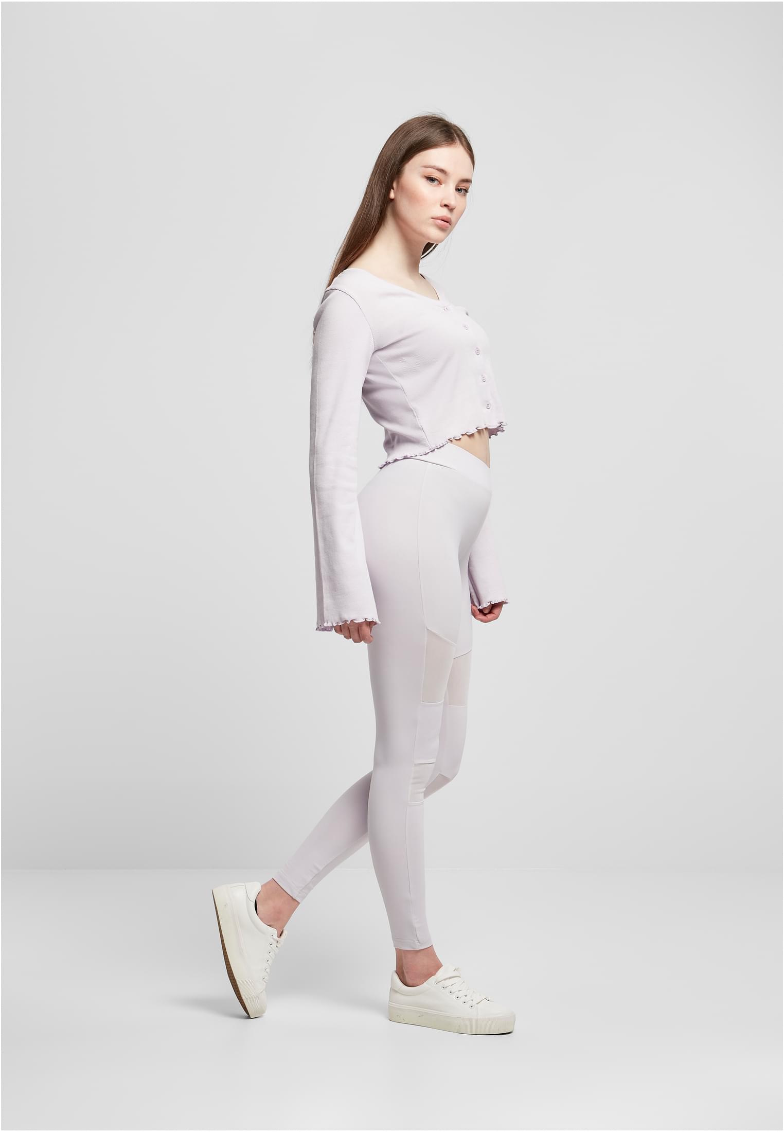 Kvinna i profil klädd i varmgrå Ladies Tech Mesh Leggings med nätpaneler och en matchande långärmad topp.