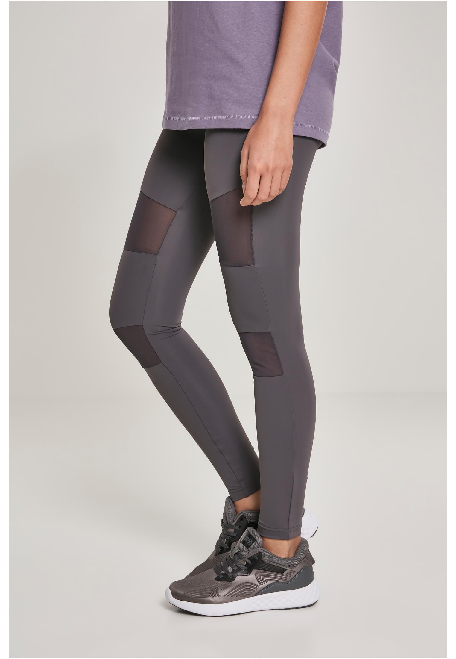 Närbild från sidan på en kvinna som bär varmgrå Ladies Tech Mesh Leggings med genomskinliga meshpaneler.
