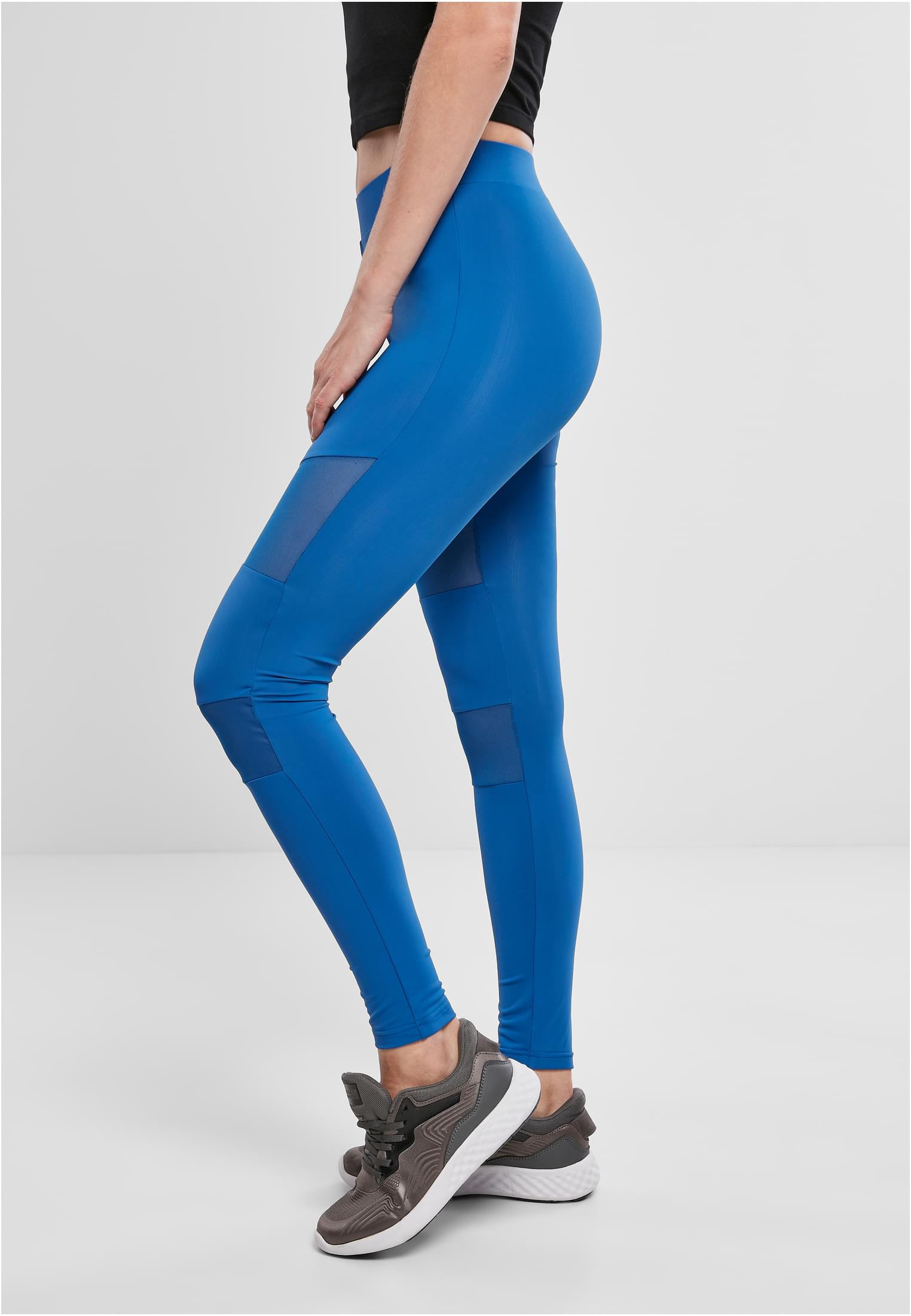 Sidovy av en kvinna som bär ett par blåa Ladies Tech Mesh Leggings med genomskinliga mesh-paneler på låren.