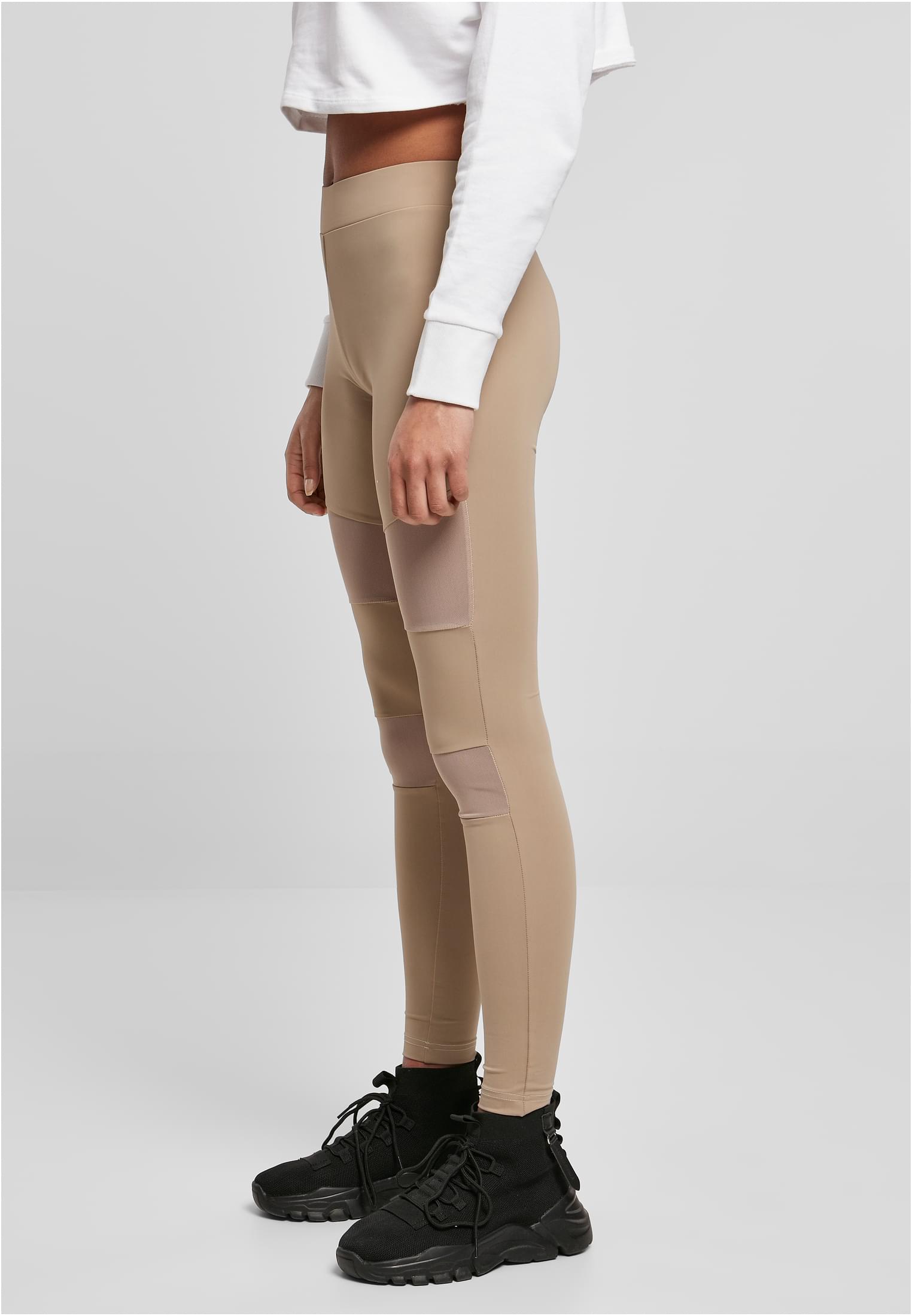 Kvinna sedd från sidan i beiga Tech Mesh Leggings med nätpaneler.