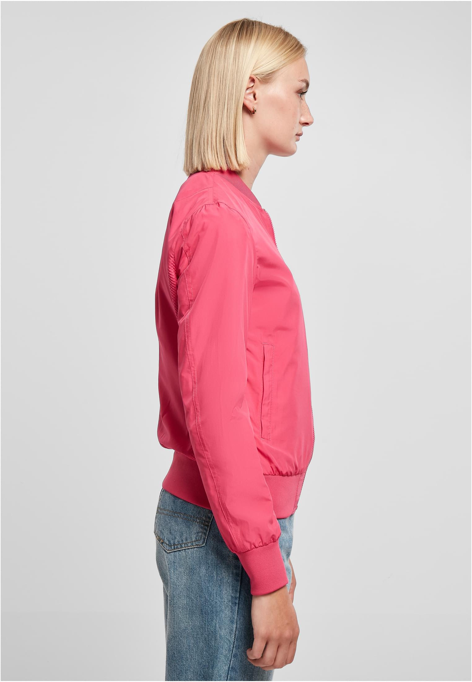 En kvinna sedd från sidan som bär den rosa UC Light Bomber Jacket.