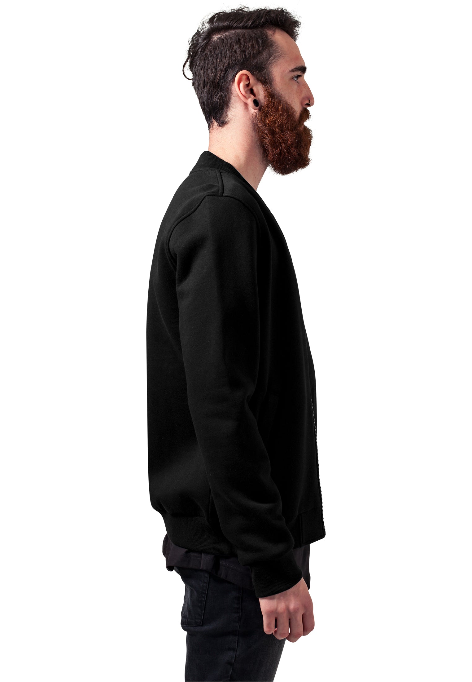 Sidovy av en man med skägg som bär en svart UC Sweat Bomber Jacket.