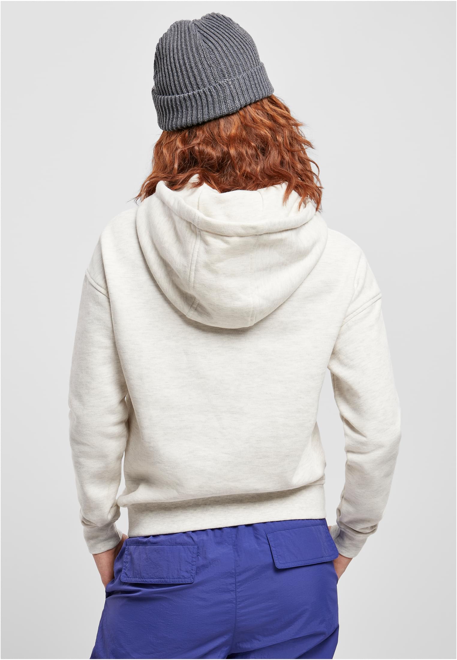 Baksidan av en kvinna med rött hår som bär en ljusgråmelerad Ladies Hoody och en mörkgrå mössa.