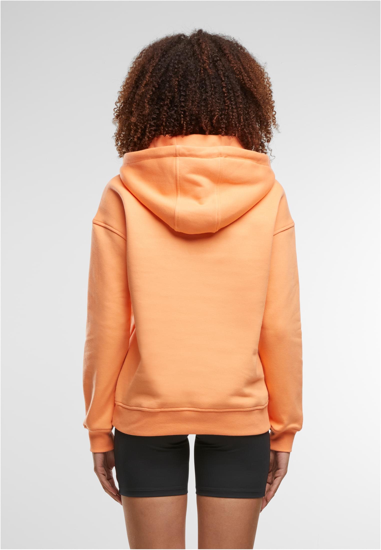 Baksidan av en kvinna som bär en ljusorange Urban Classics Ladies Hoody.