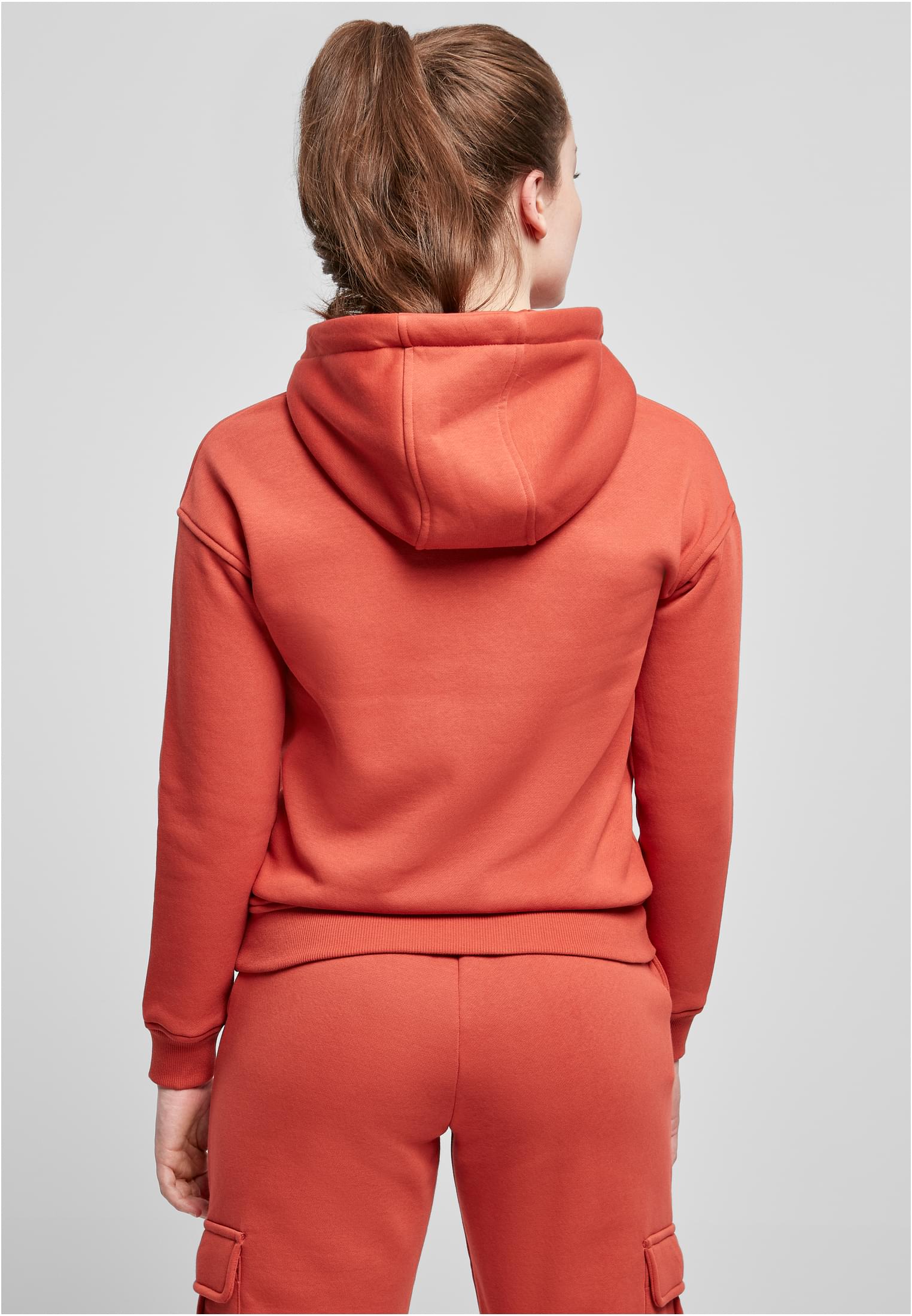 Baksidan av en kvinna som bär en rostfärgad UC Ladies Hoody.