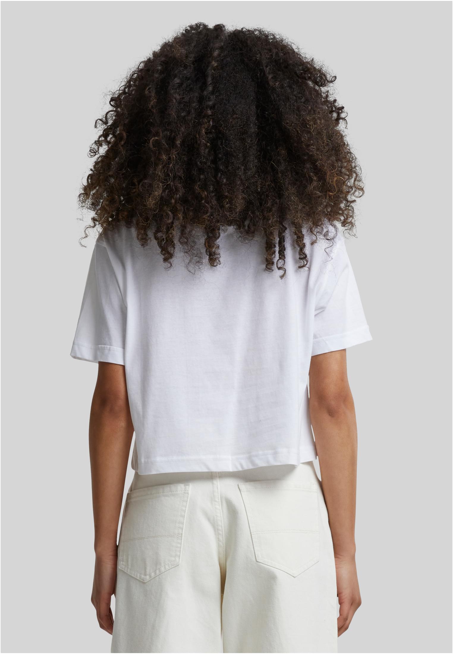 Kvinna sedd bakifrån som bär en vit, kort och oversized t-shirt.