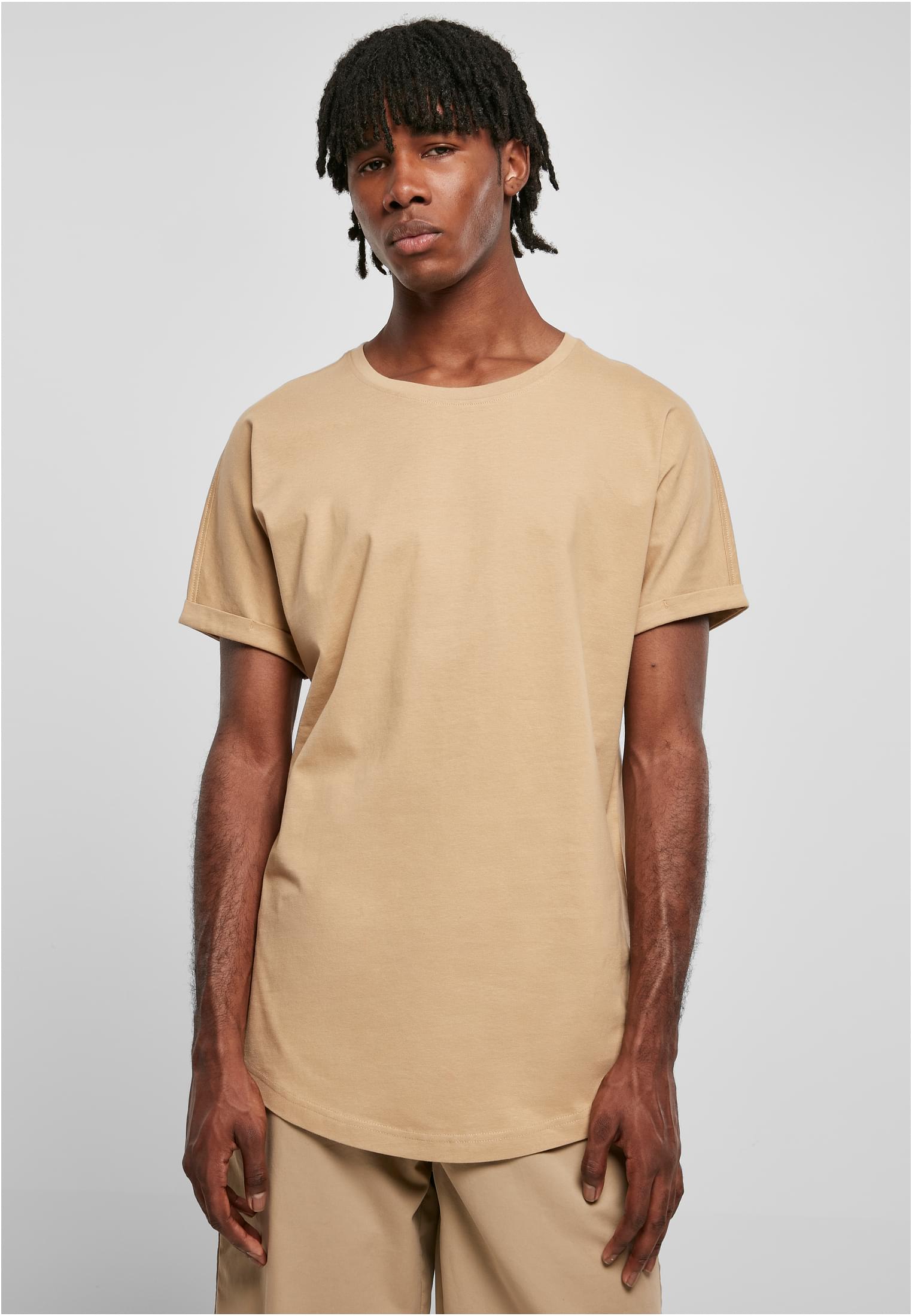 En manlig modell visar framsidan av en terrakottafärgad Long Shaped Turnup Tee från Urban Classics.