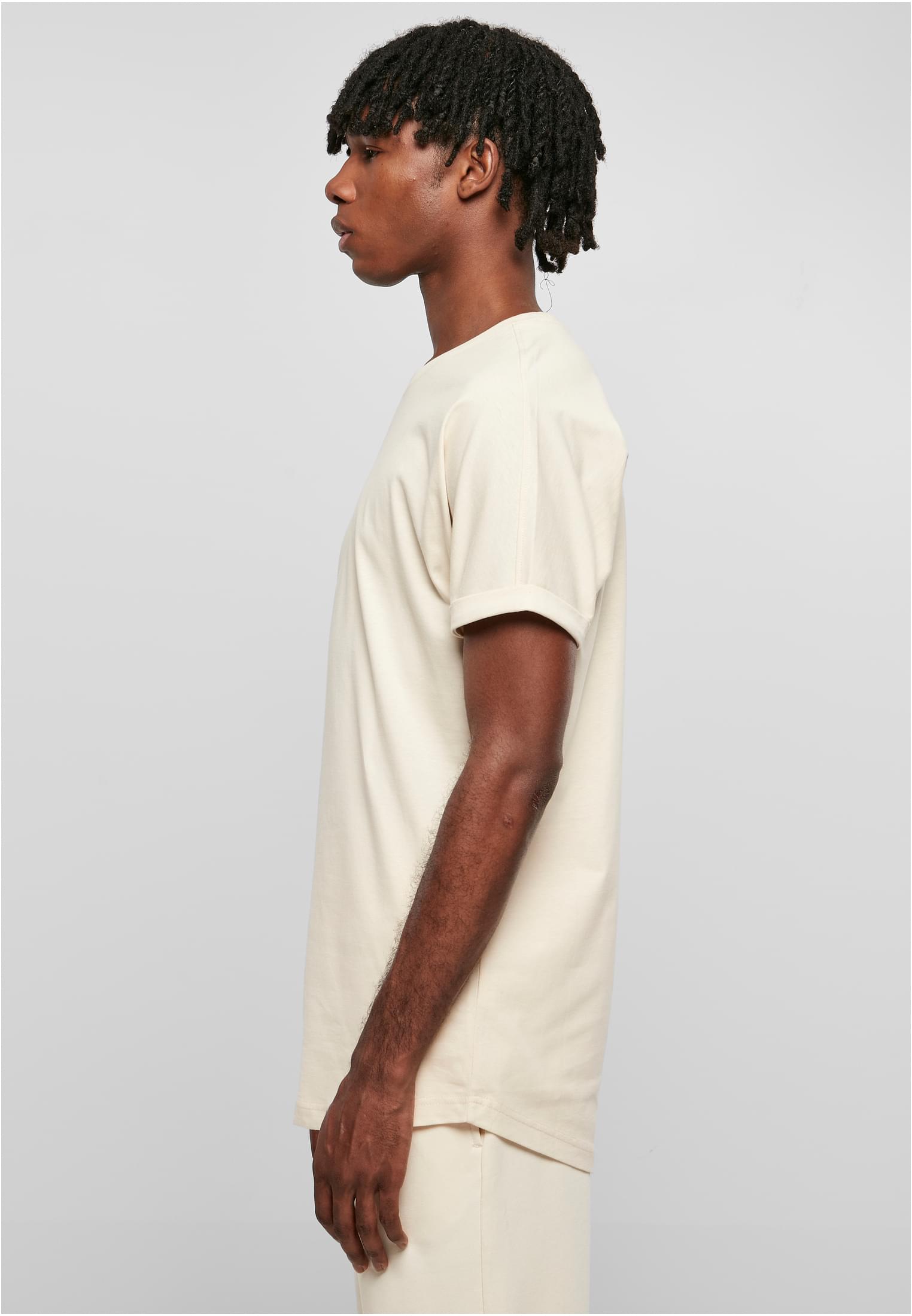 Man i profil som bär en ljusbeige Long Shaped Turnup Tee från Urban Classics.