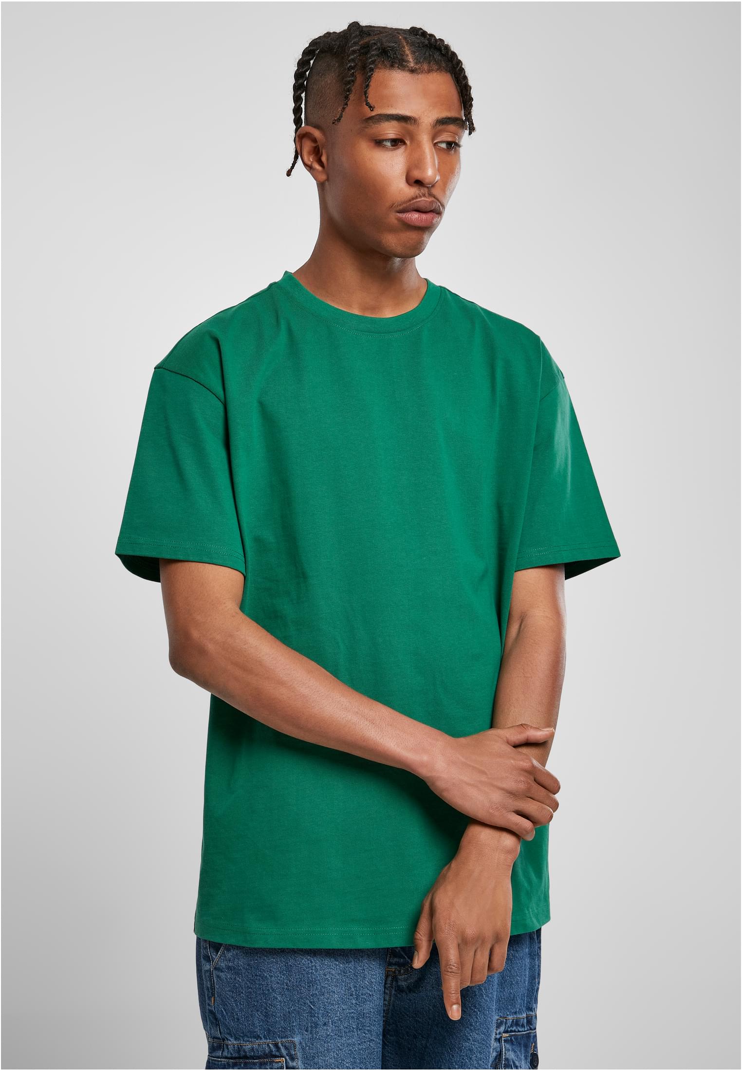 En manlig modell som bär en grön Heavy Oversized Tee.