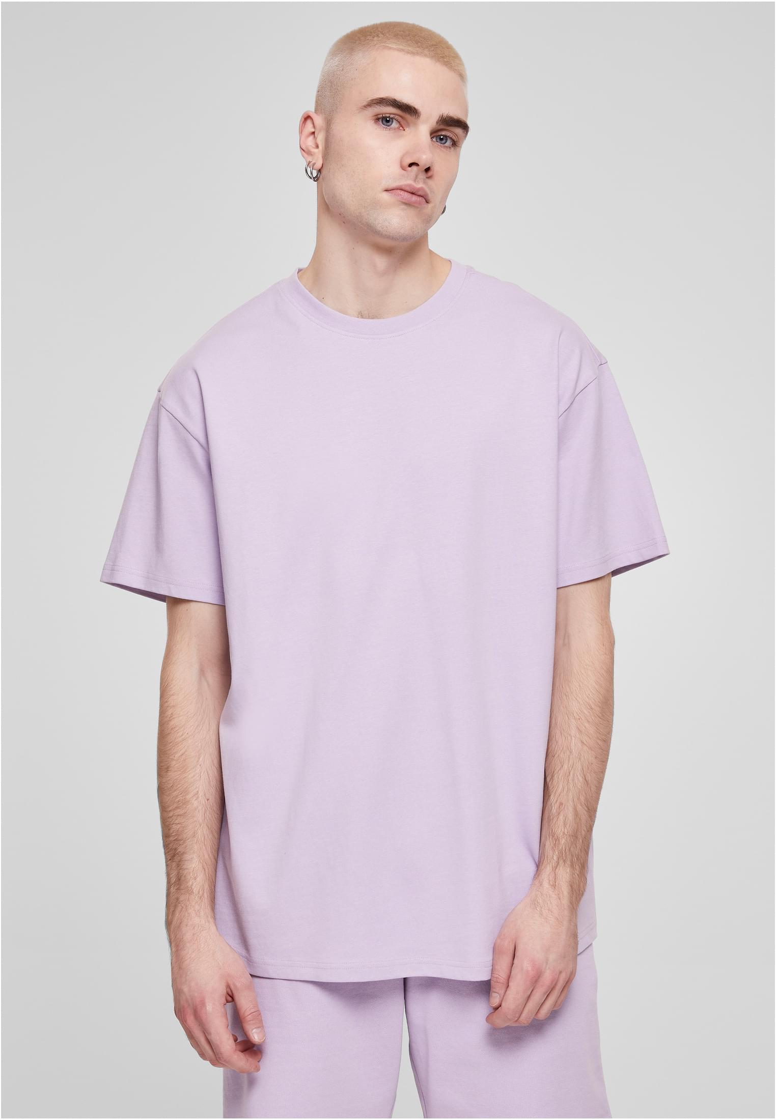 Manlig modell som bär en ljuslila Heavy Oversized Tee från Urban Classics.