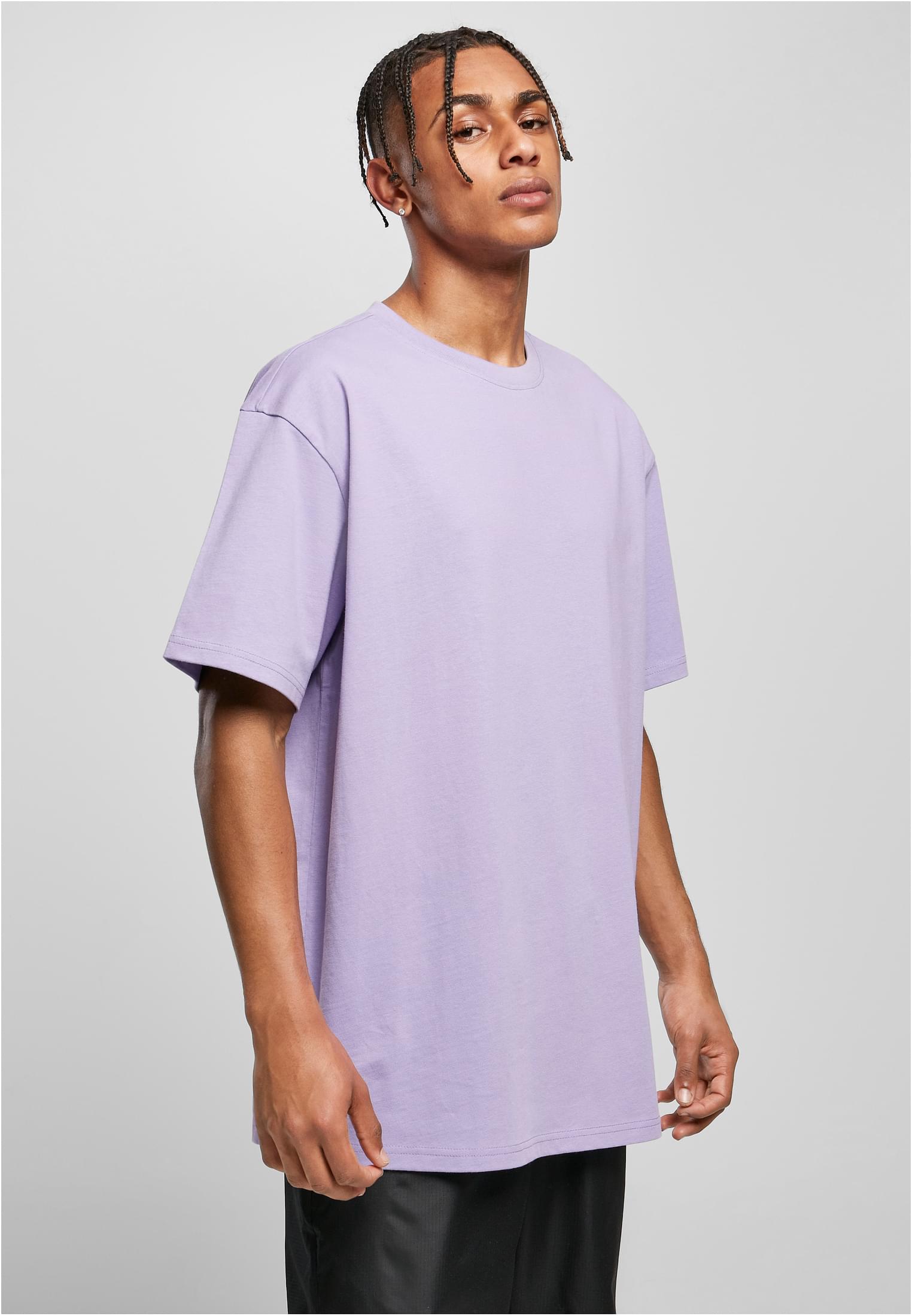 En manlig modell som bär en ljuslila Heavy Oversized T-shirt från Urban Classics.